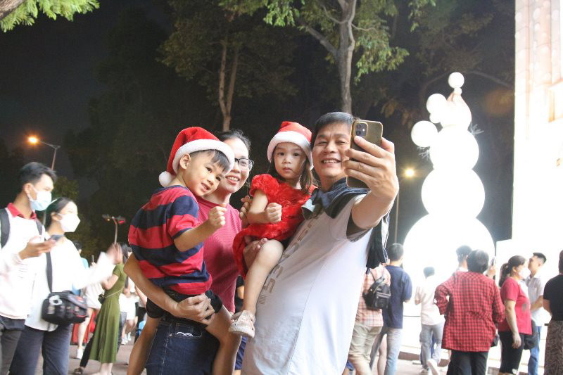 Một gia đình đón Noel trước trung tâm thương mại trên đường Lê Duẩn, quận 1