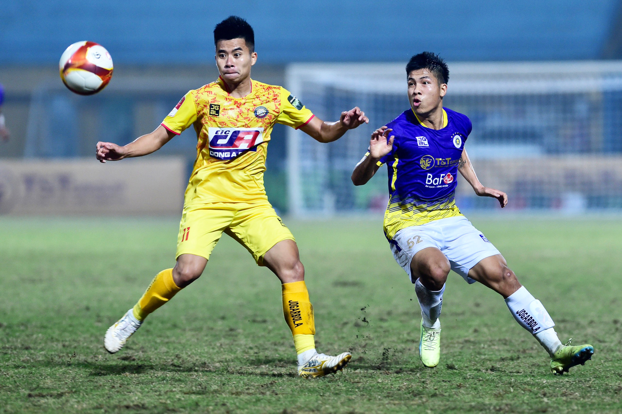 Lê Phạm Thành Long (áo vàng) tranh chấp bóng cùng Lê Văn Vĩ.
