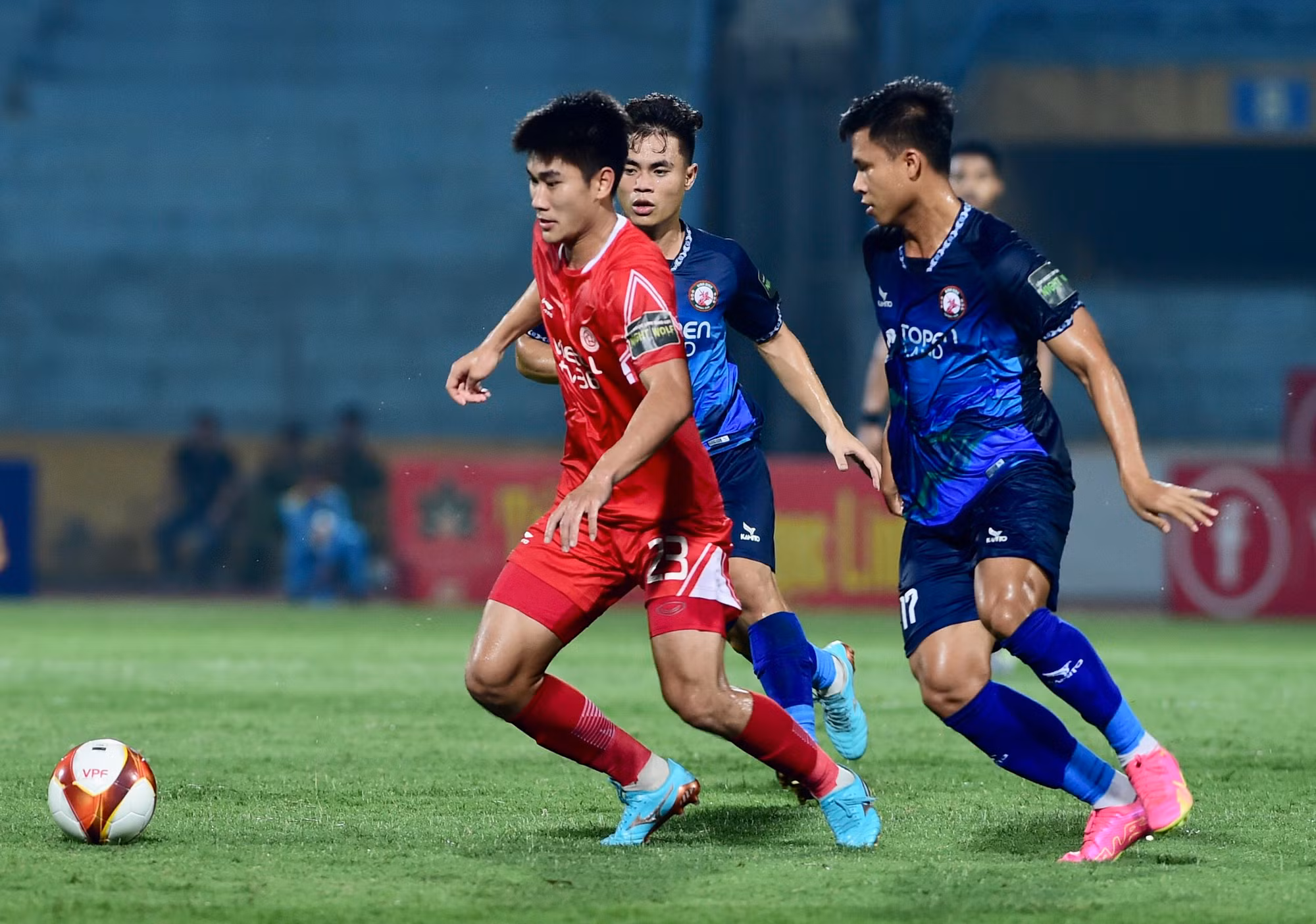 Nhâm Mạnh Dũng vượt qua sự truy cản của cầu thủ Bình Định.