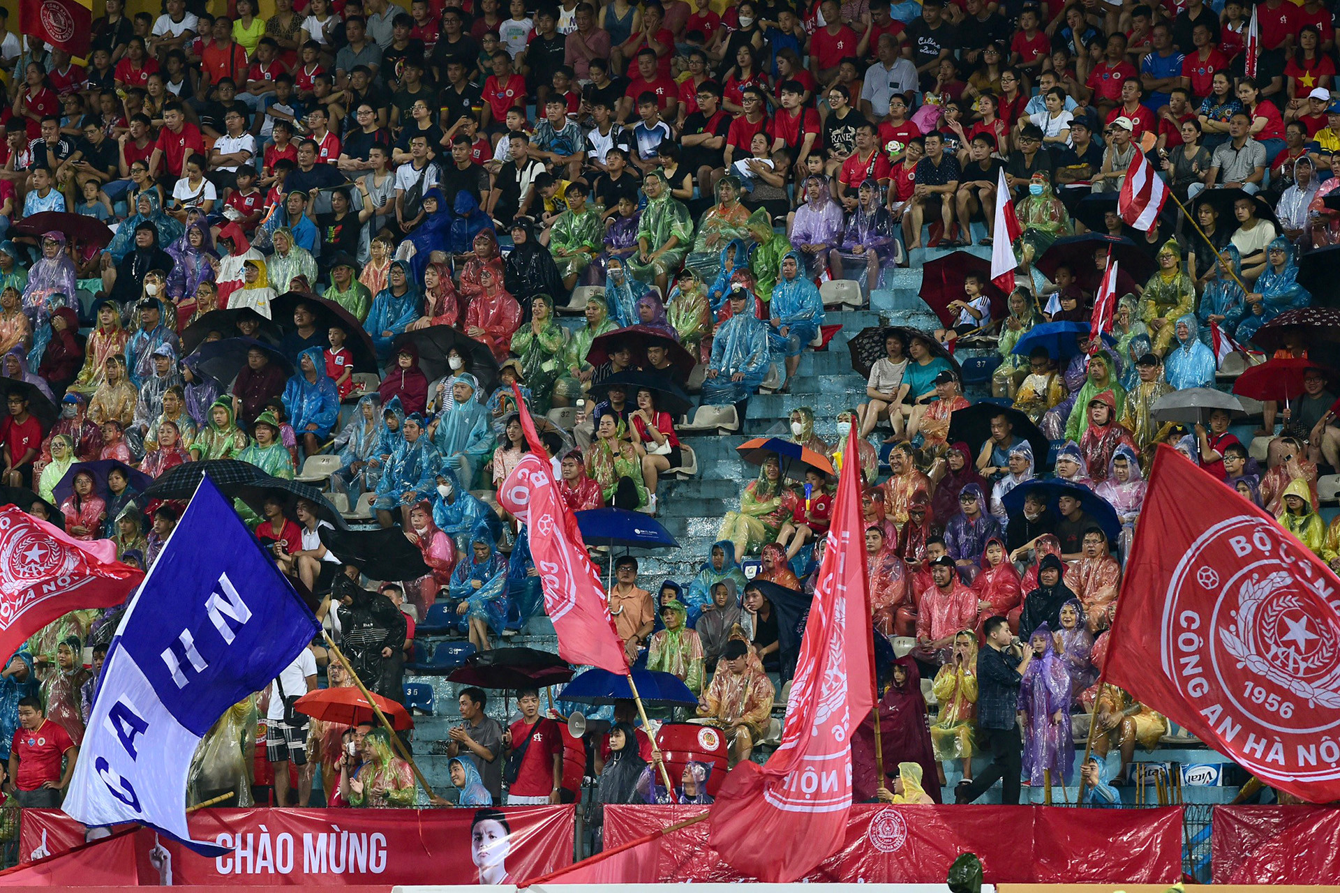 Cổ động viên Công an Hà Nội mặc áo mưa để theo dõi đội nhà.