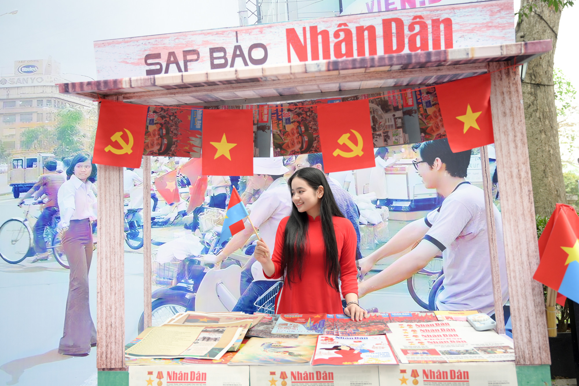 Các bạn trẻ check-in tại sạp Báo Nhân Dân trong khuôn viên triển lãm.