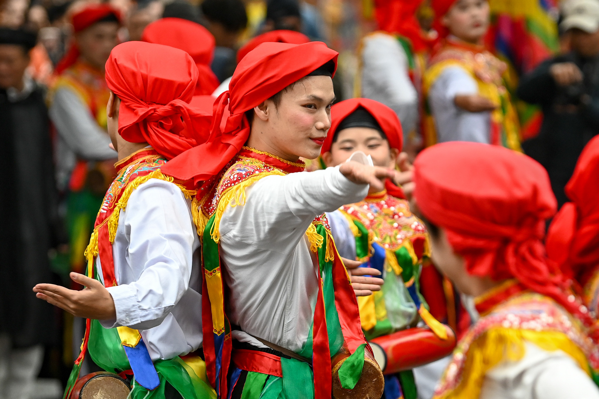 Các chàng trai giả gái mặt hoa da phấn, động tác uyển chuyển, mềm mại, xúng xính trong áo tứ thân, váy đụp, đeo bông tai, chít khăn mỏ quạ và mỗi người đeo một cái trống bồng nhỏ sơn màu đỏ trước ngực.