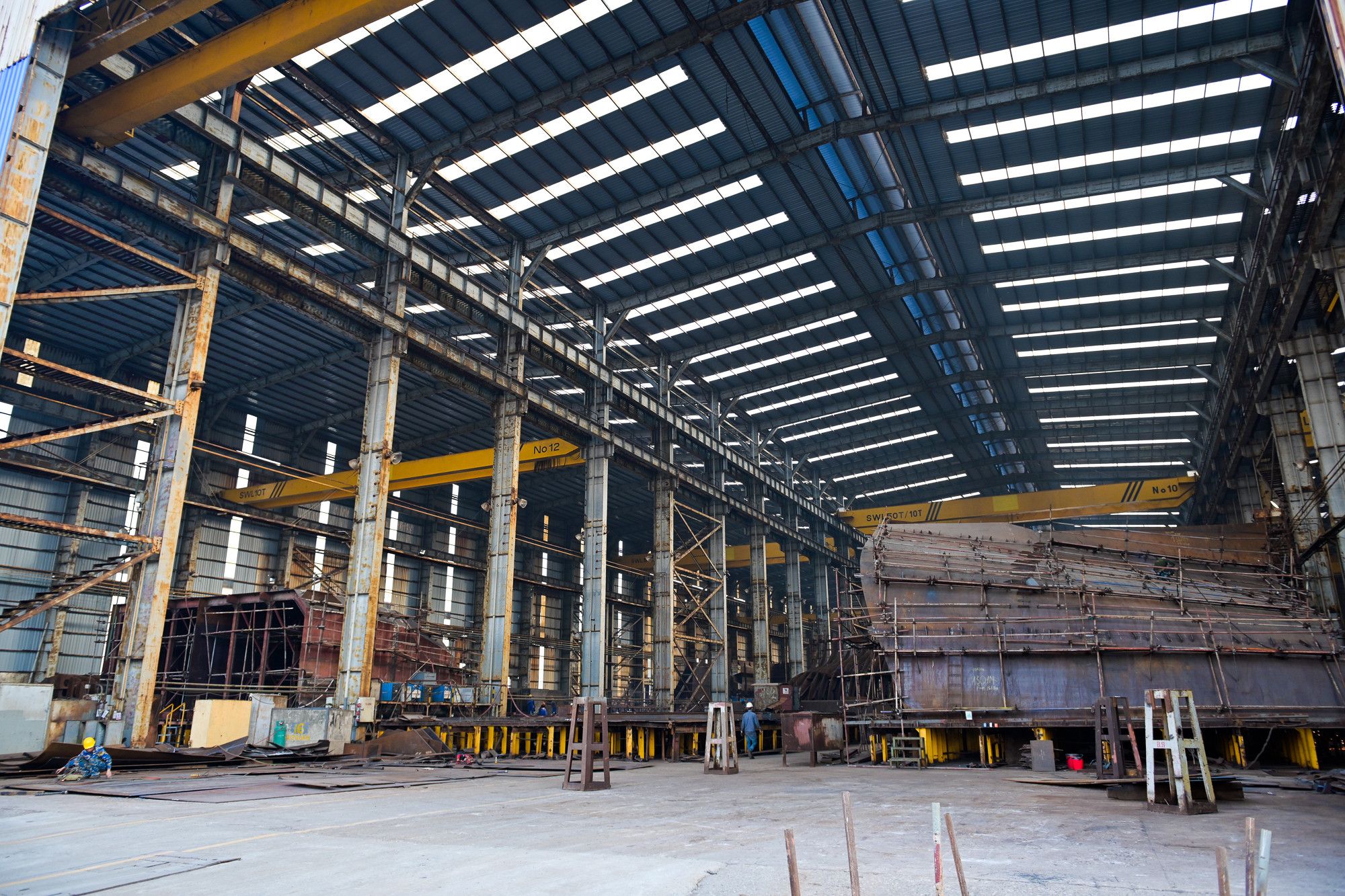 Phân xưởng rộng hàng nghìn mét vuông cùng những cấu kiện tàu khổng lồ. Phân xưởng rộng hàng nghìn mét vuông cùng những cấu kiện tàu khổng lồ.