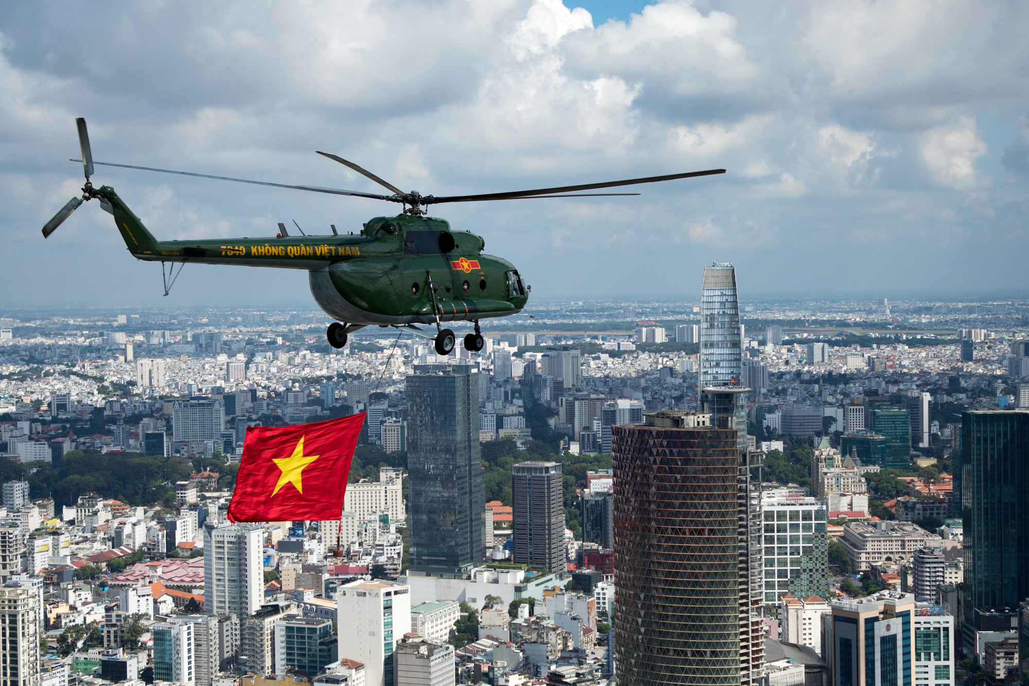 Trực thăng kéo cờ Tổ quốc bay qua tòa nhà Bitexco (quận 1).