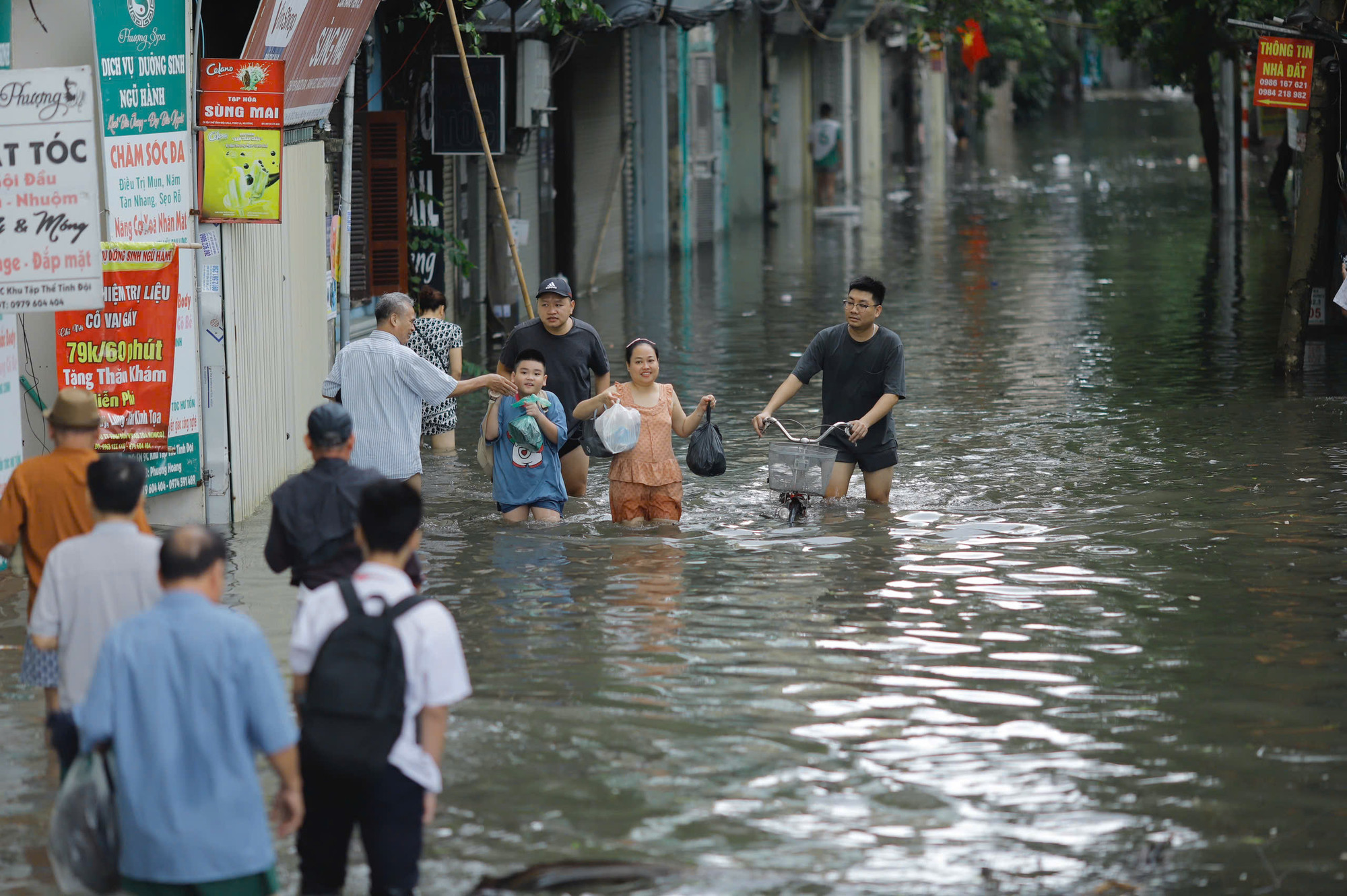 Tại Mậu Lương (Hà Đông) nước lên nhanh, người dân bì bõm di chuyển đi học, đi làm.