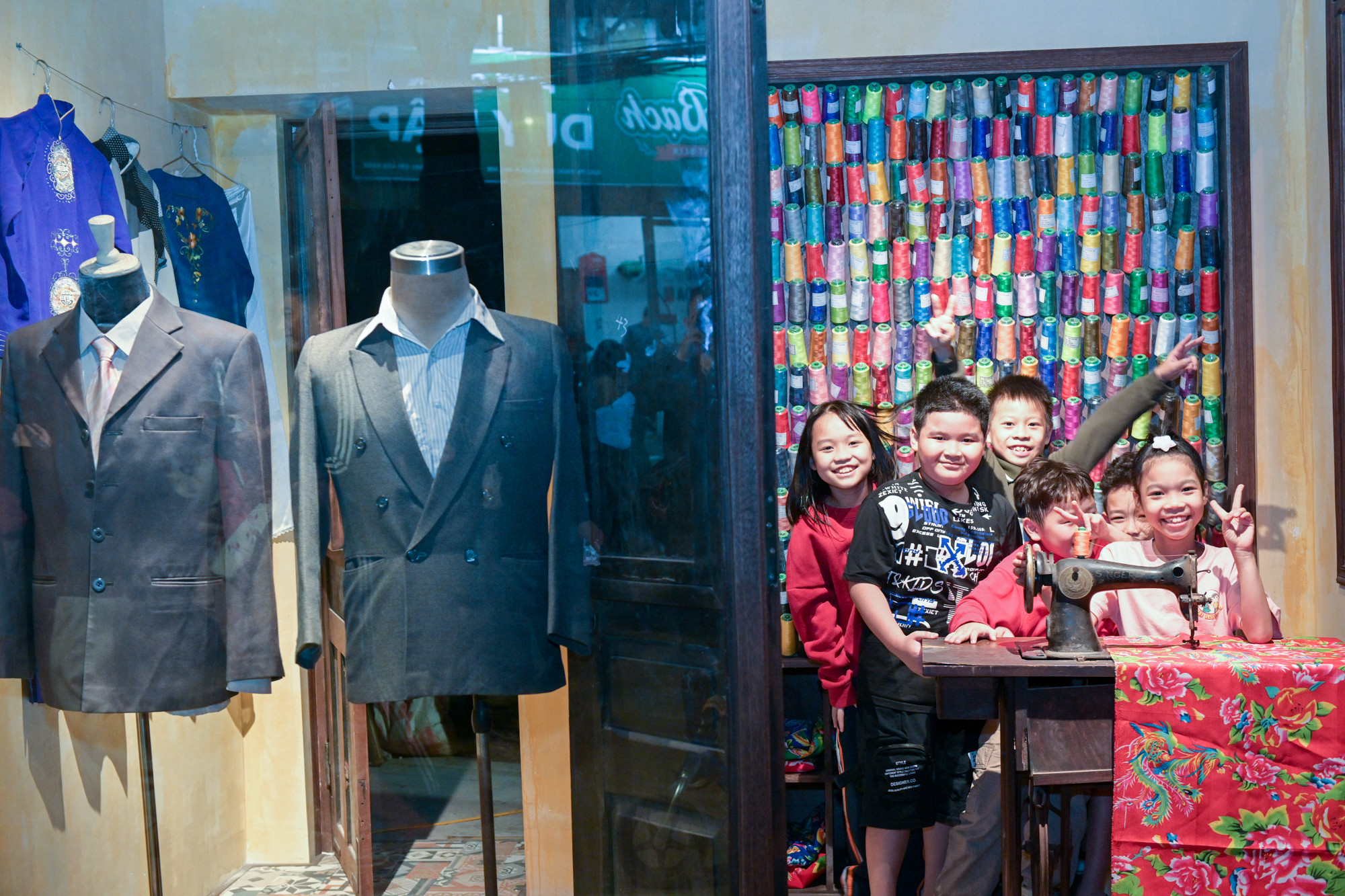 Nhiều bạn nhỏ thích thú với chiếc máy may và tấm vải hình con công.