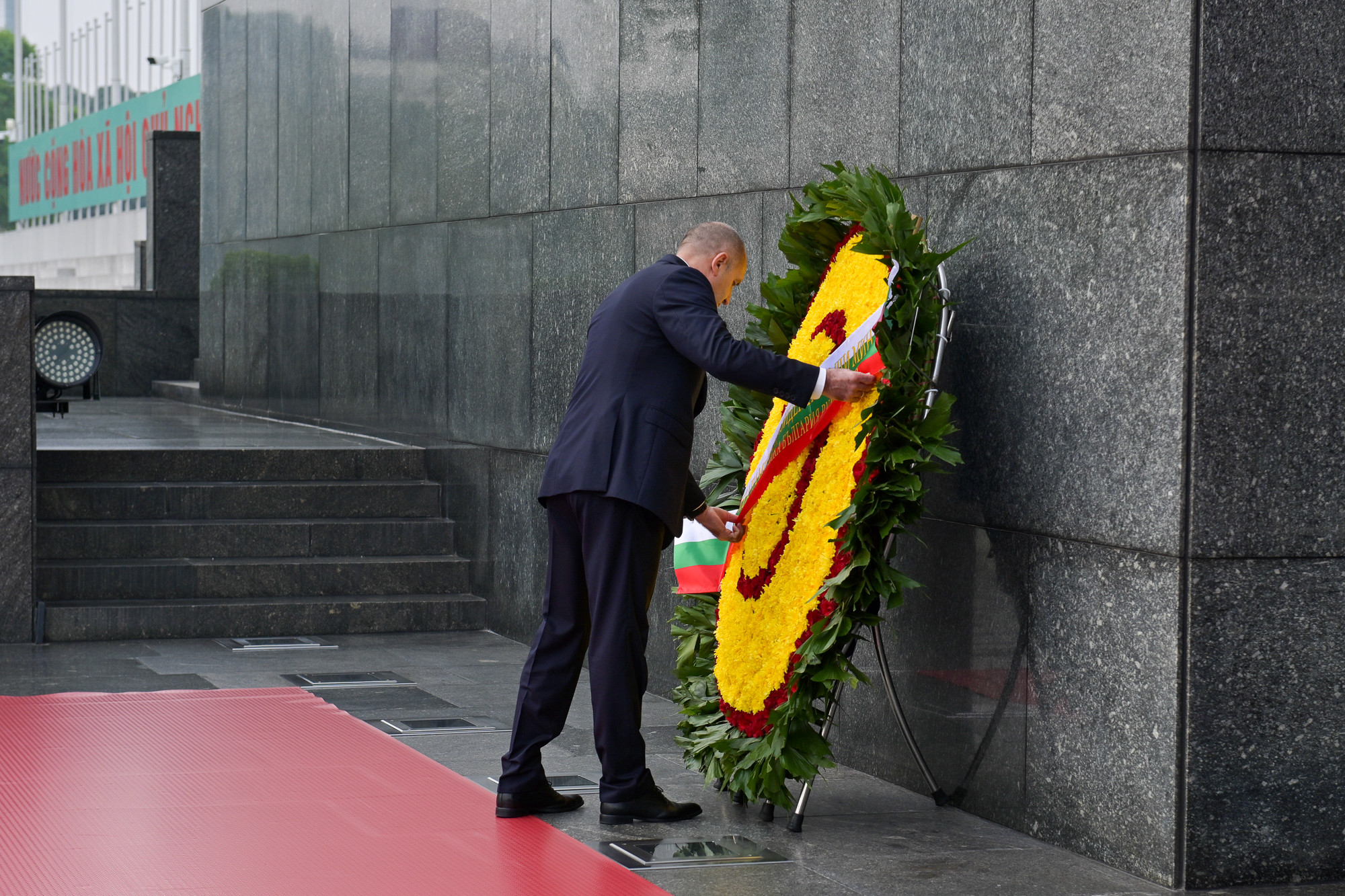 Tổng thống Bulgaria Rumen Radev chỉnh dòng chữ trên vòng hoa.