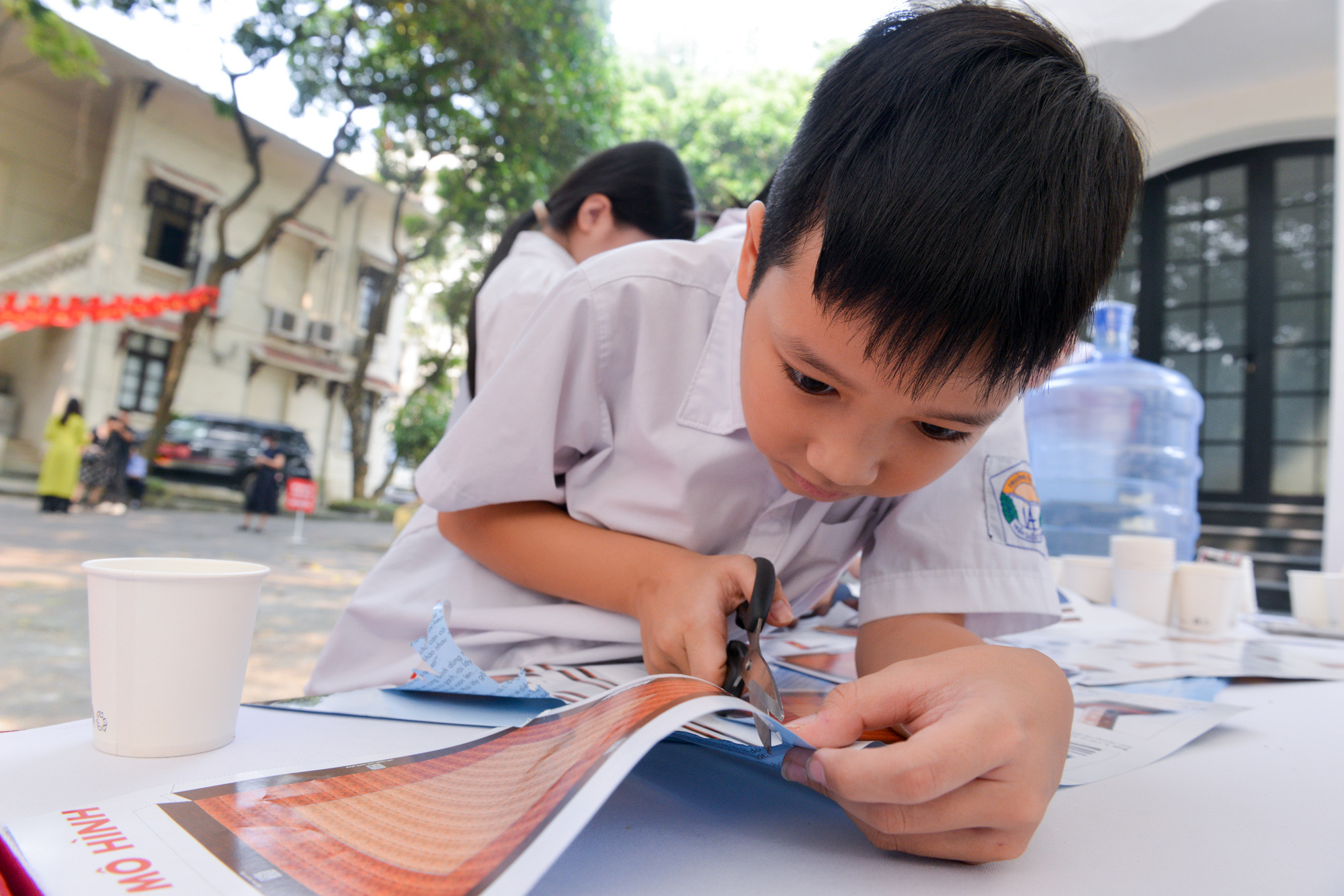 Các bạn học sinh chăm chú cắt, ghép mô hình Cột cờ Hà Nội.