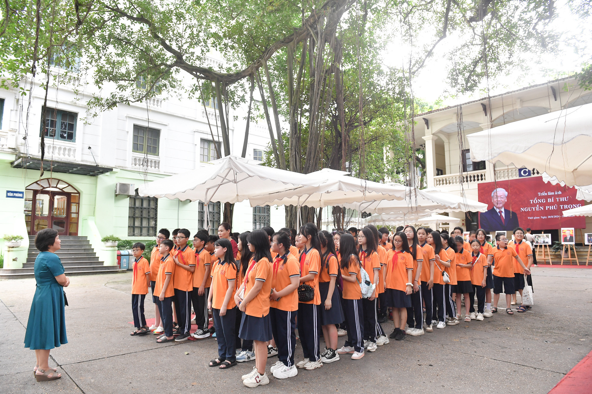 Cán bộ của Báo Nhân Dân giới thiệu cho học sinh Trường trung học cơ sở Nguyễn Trãi về nội dung của triển lãm.