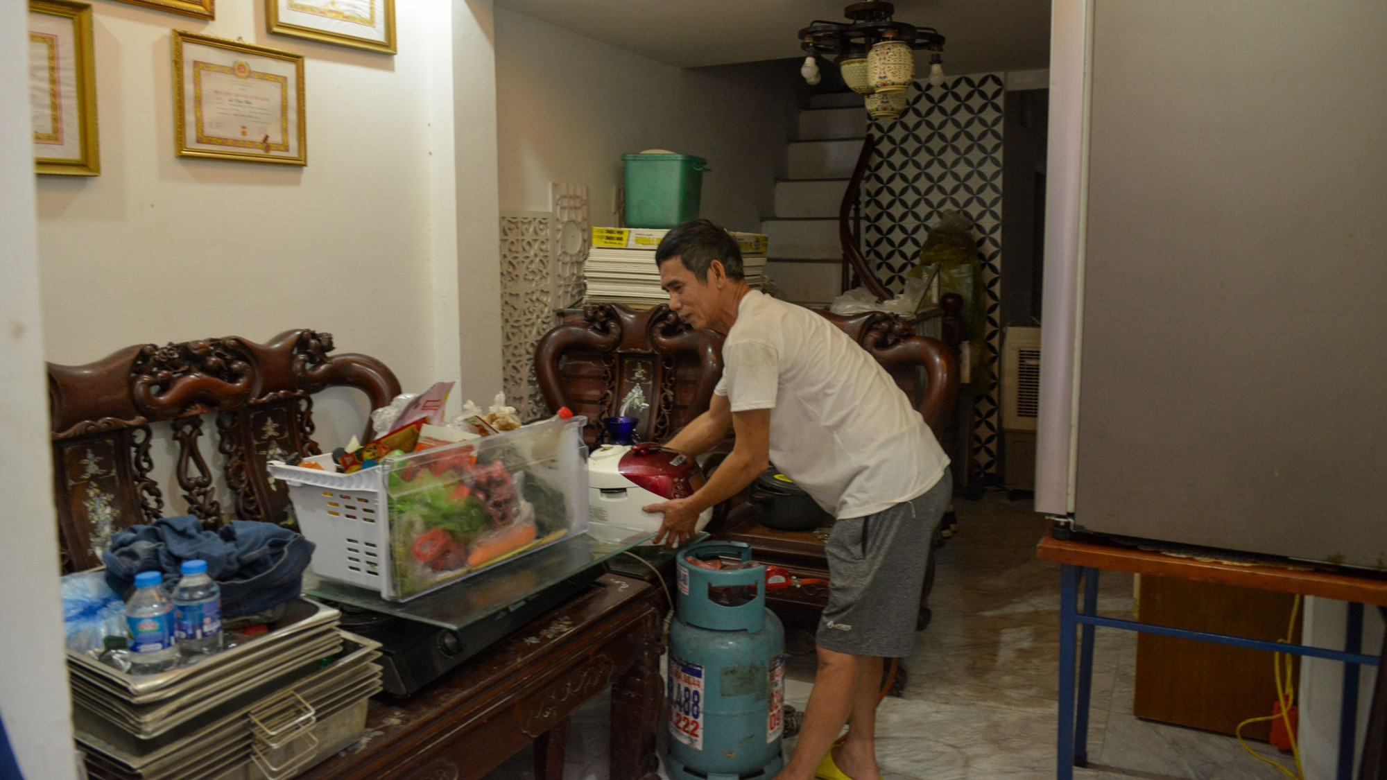 Người dân tại ngõ 661 Bạch Đằng dọn dẹp, kê cao đồ đạc lên cao đề phòng nước dâng cao.