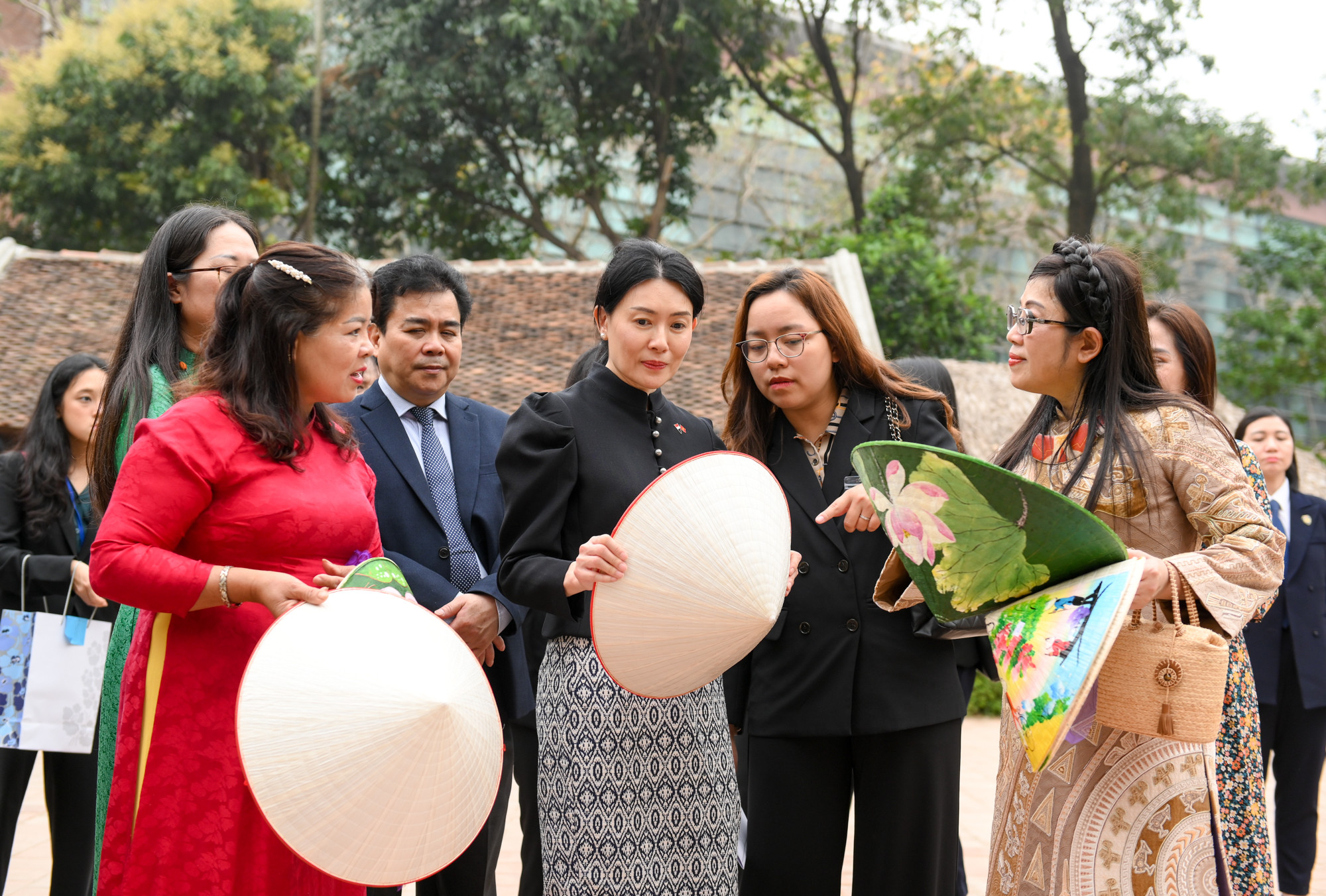 Nghệ nhân làng Chuông giới thiệu với hai phu nhân về nón lá truyền thống và sản phẩm nón lá mới của người Việt. Nghệ nhân làng Chuông giới thiệu với hai phu nhân về nón lá truyền thống và sản phẩm nón lá mới của người Việt.