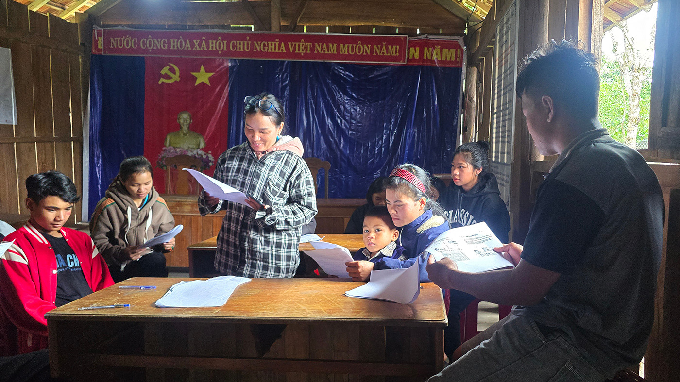 Người dân thôn Vi Xây, xã Đăk Tăng tìm hiểu về động đất qua Sổ tay hướng dẫn về ứng phó với động đất.