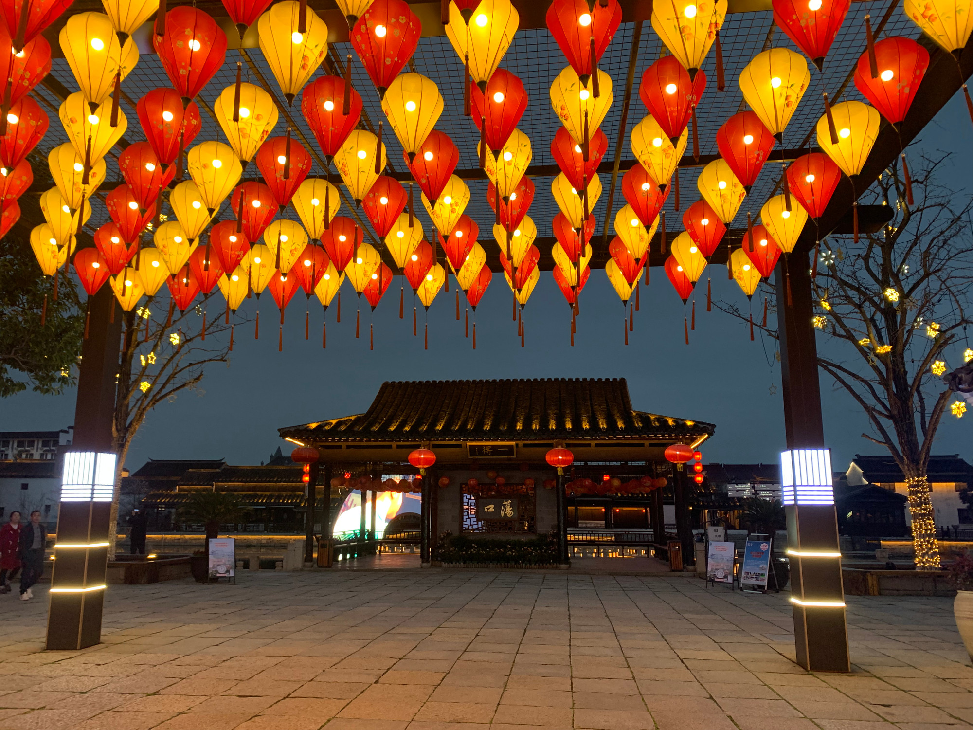 Cổng vào cổ trấn được trang trí bởi những chiếc đèn lồng rực rỡ. (Ảnh: HỮU HƯNG)