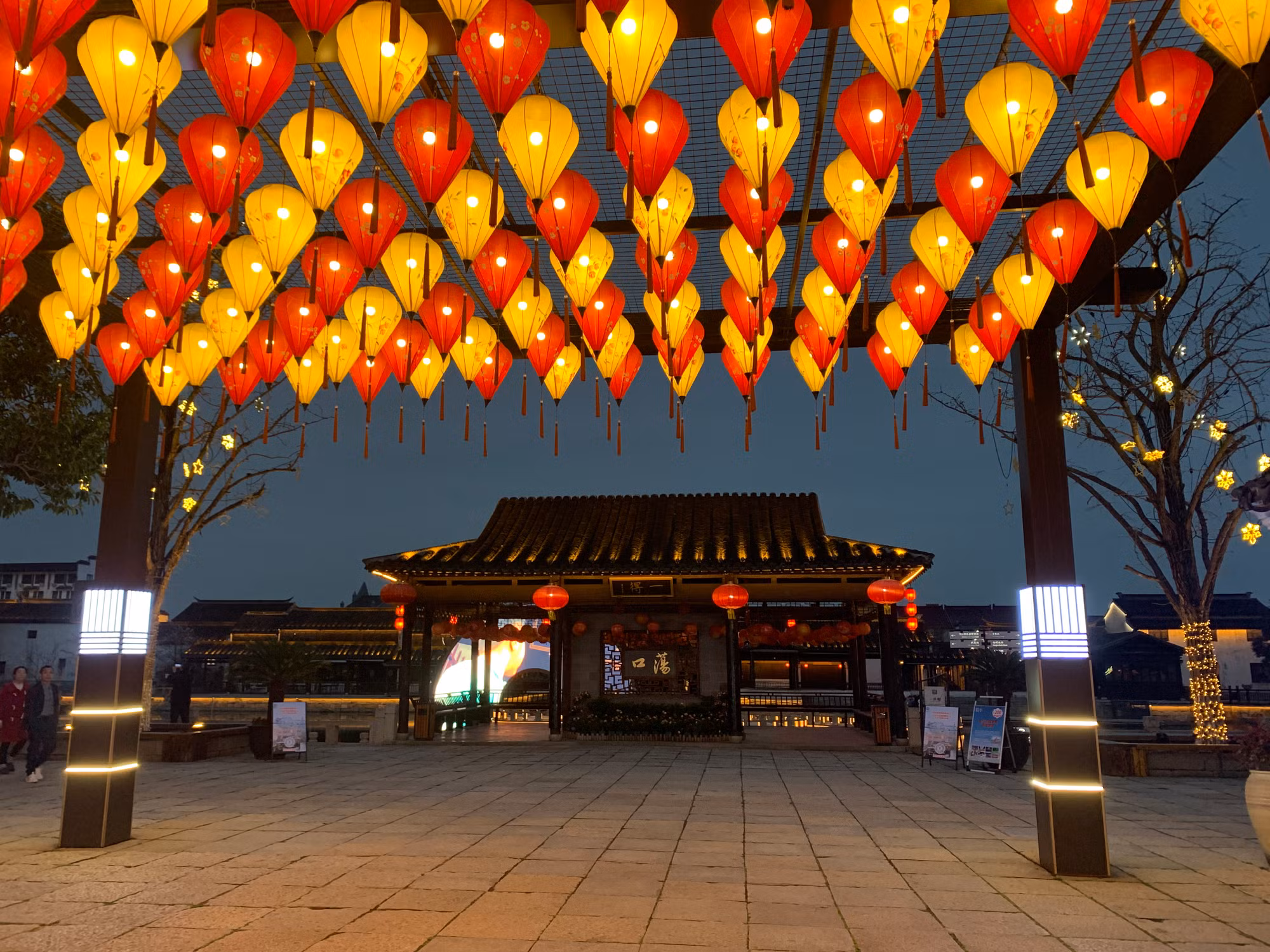 Cổng vào cổ trấn được trang trí bởi những chiếc đèn lồng rực rỡ. (Ảnh: HỮU HƯNG)