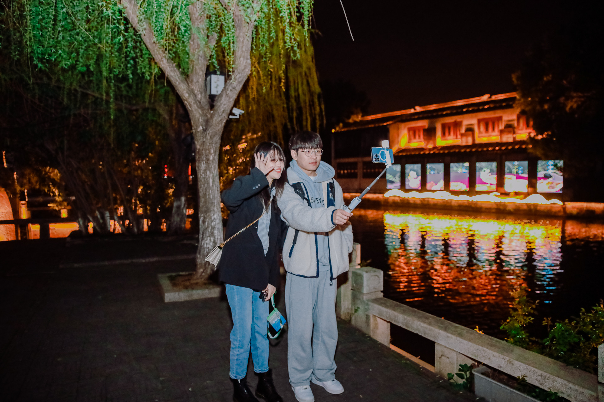 2 bạn trẻ chụp ảnh bên sông.