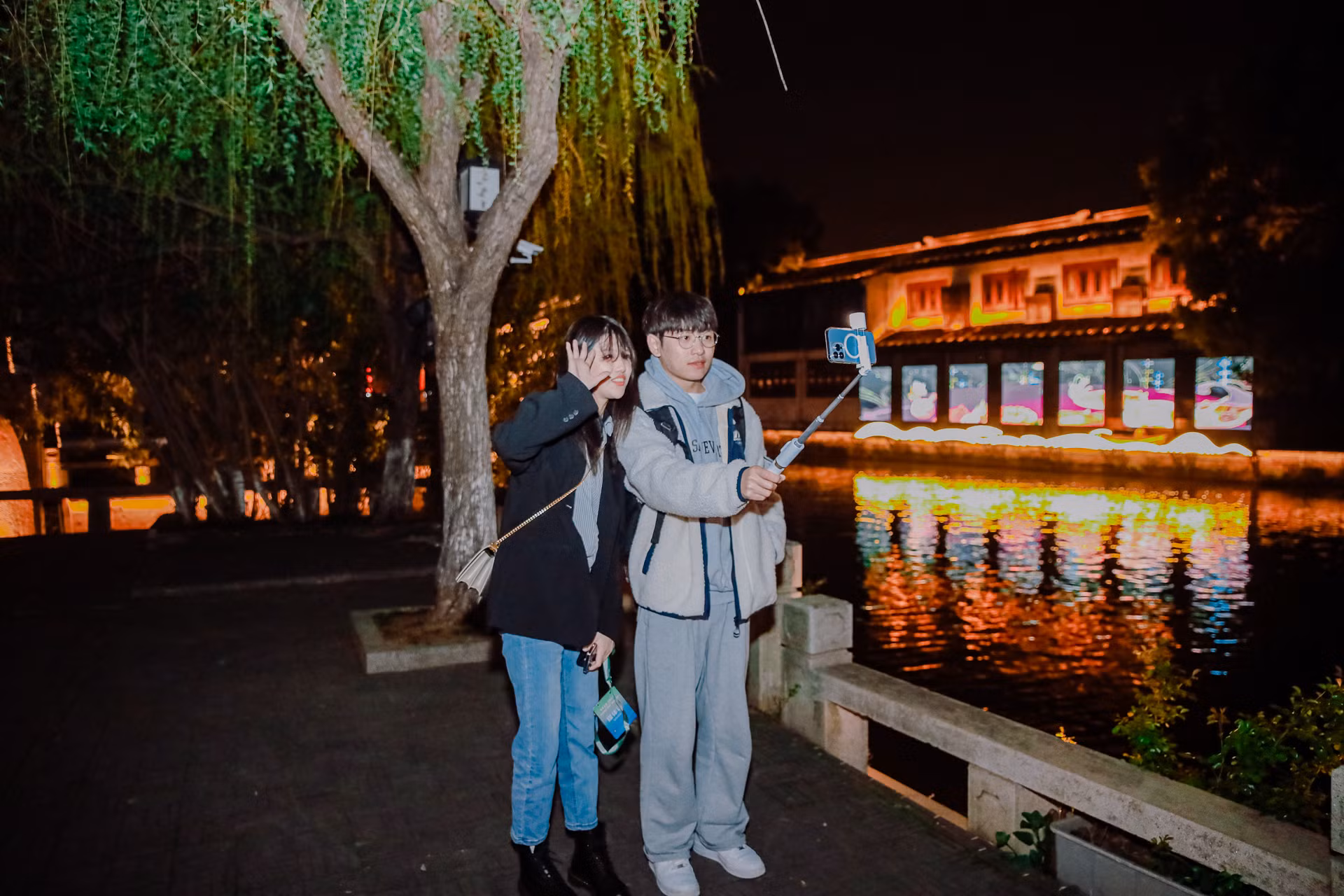 2 bạn trẻ chụp ảnh bên sông.