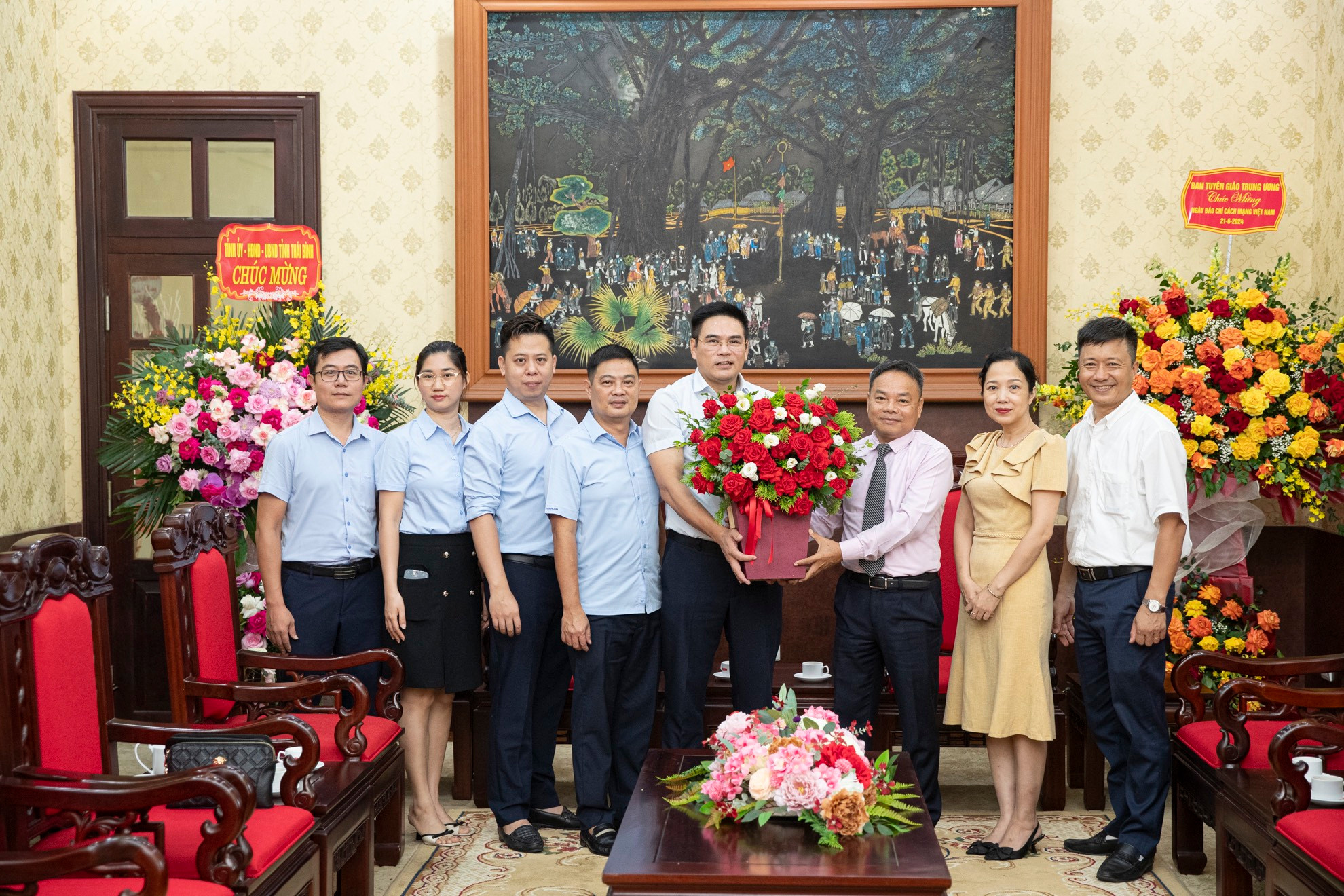 Phó Tổng Biên tập Báo Nhân Dân Đinh Như Hoan nhận lẵng hoa tươi thắm của Công ty Nước sạch Hà Nội do đồng chí Đặng Ngọc Hải, Phó Tổng Giám đốc Công ty dẫn đầu.