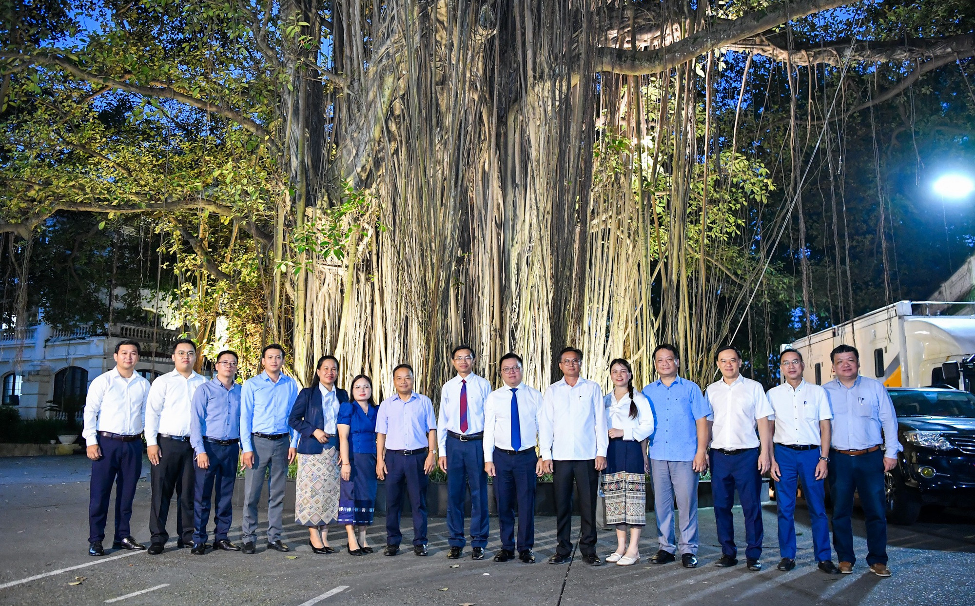 Lãnh đạo, cán bộ Báo Nhân Dân chụp ảnh lưu niệm cùng Đoàn công tác Báo Pasaxon bên Cây Đa tại 71 Hàng Trống. (Ảnh: THÀNH ĐẠT)
