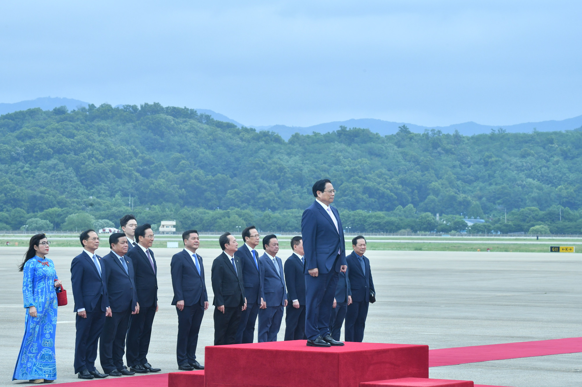 Thủ tướng Phạm Minh Chính đứng tại bục danh dự trong lúc Đội quân nhạc cử quốc thiều Việt Nam.