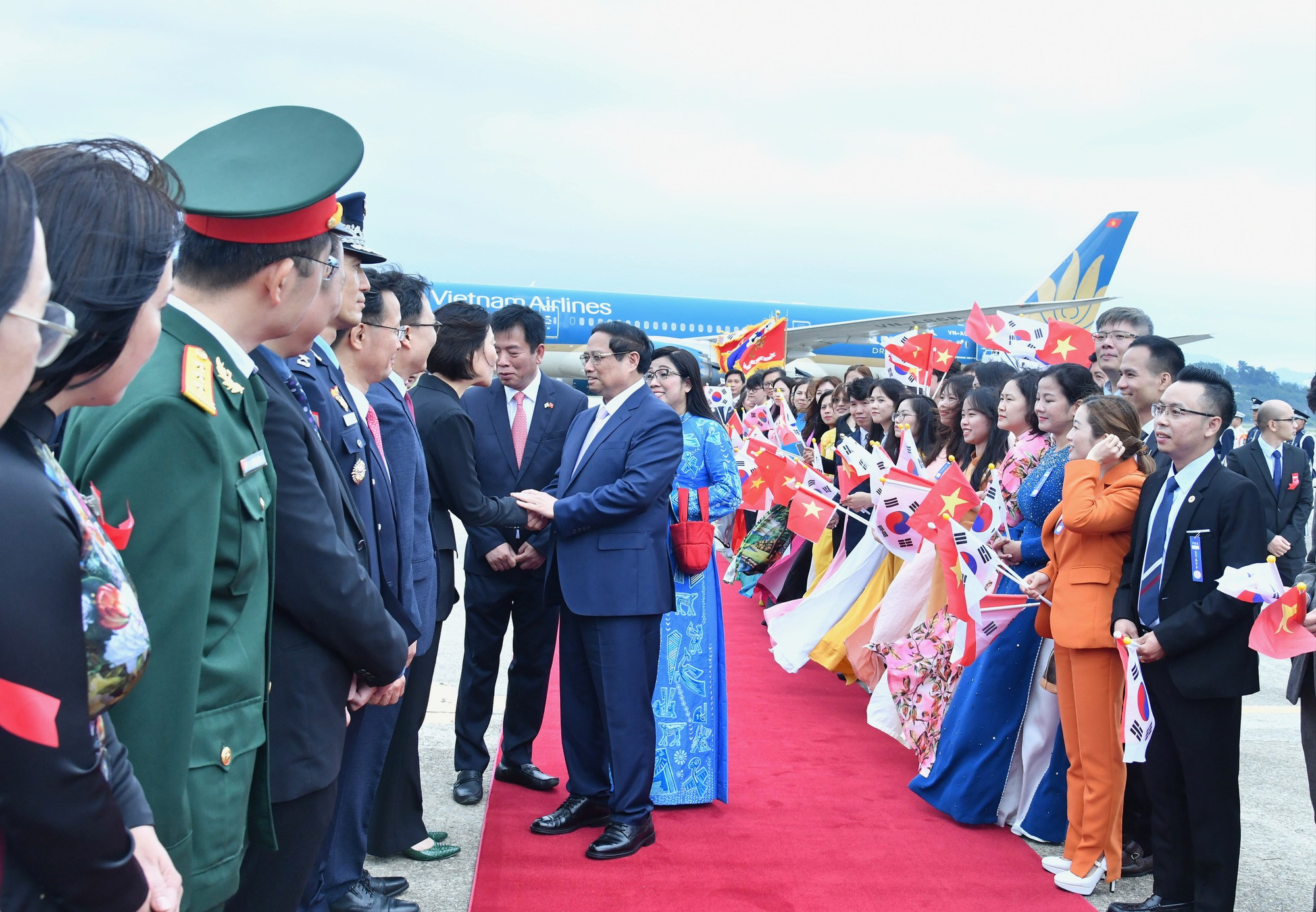 Thủ tướng Phạm Minh Chính và Phu nhân bắt tay quan chức Hàn Quốc tại Lễ đón chính thức.