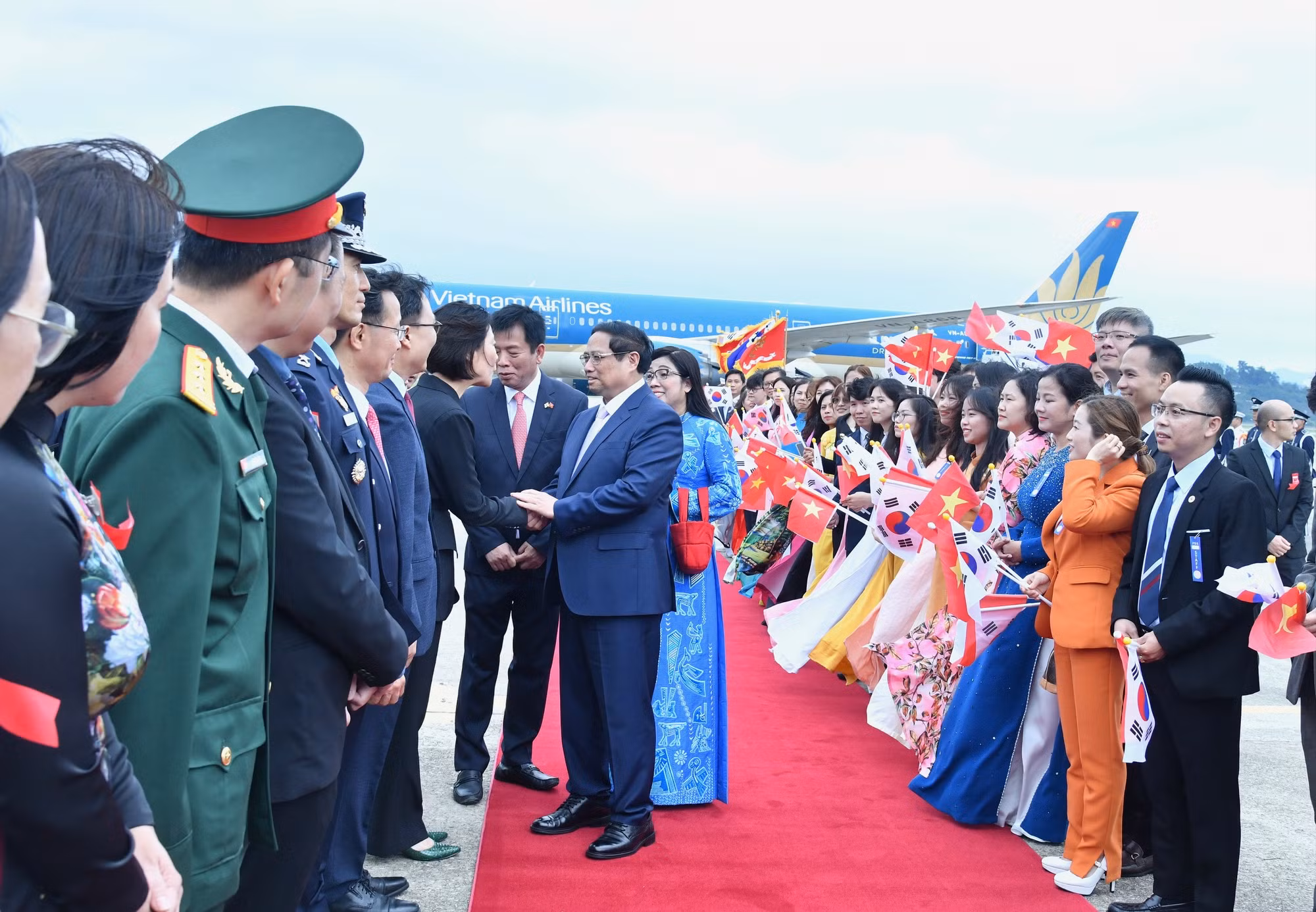 Thủ tướng Phạm Minh Chính và Phu nhân bắt tay quan chức Hàn Quốc tại Lễ đón chính thức.