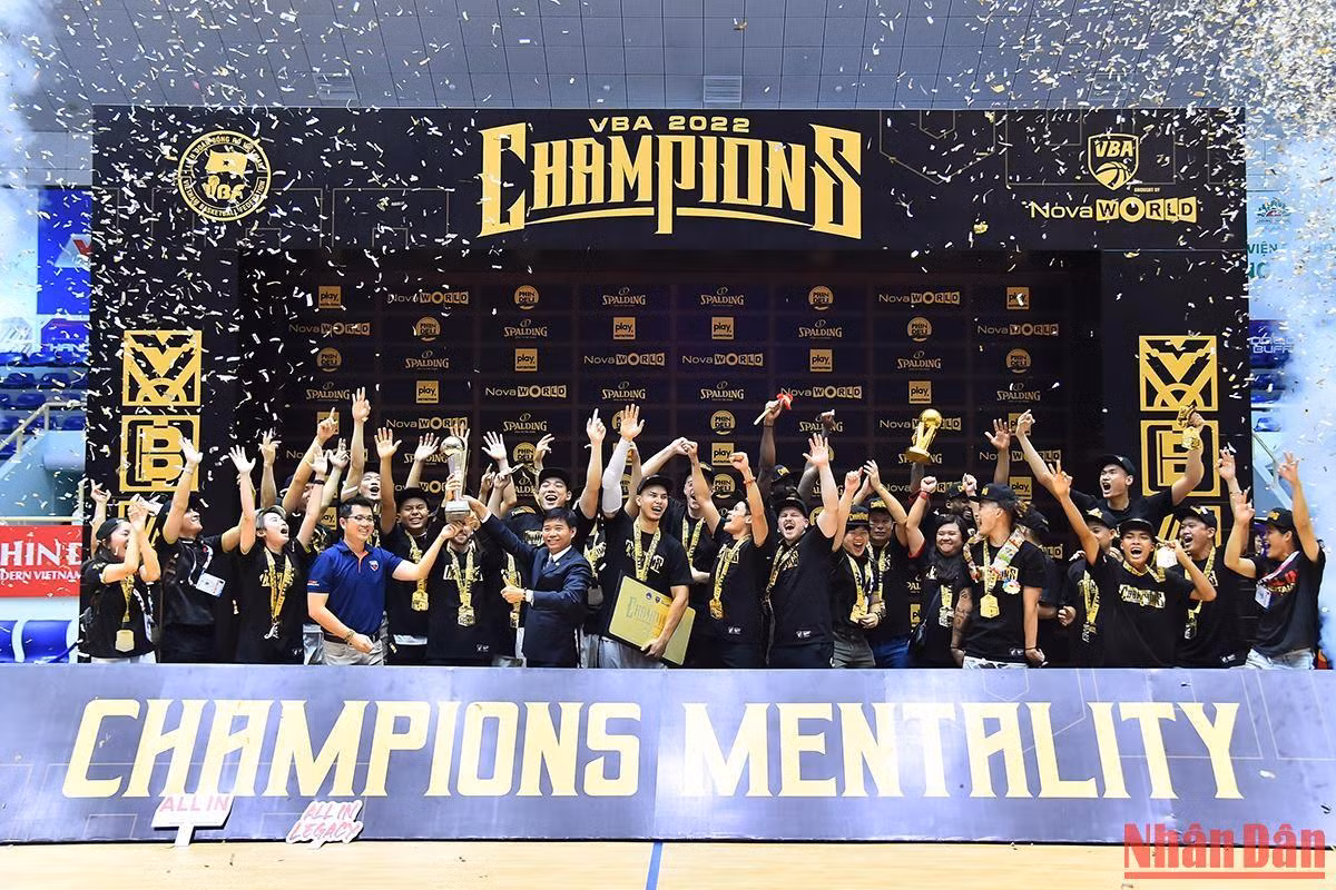 Các cầu thủ cùng ban huấn luyện Saigon Heat nâng cao chiếc cup vô địch Giải Bóng rổ chuyên nghiệp Việt Nam - VBA 2022 từ Giám đốc điều hành giải đấu Trần Chu Sa và Tổng Giám đốc Nova Consumer Nguyễn Quang Phi Tín.
