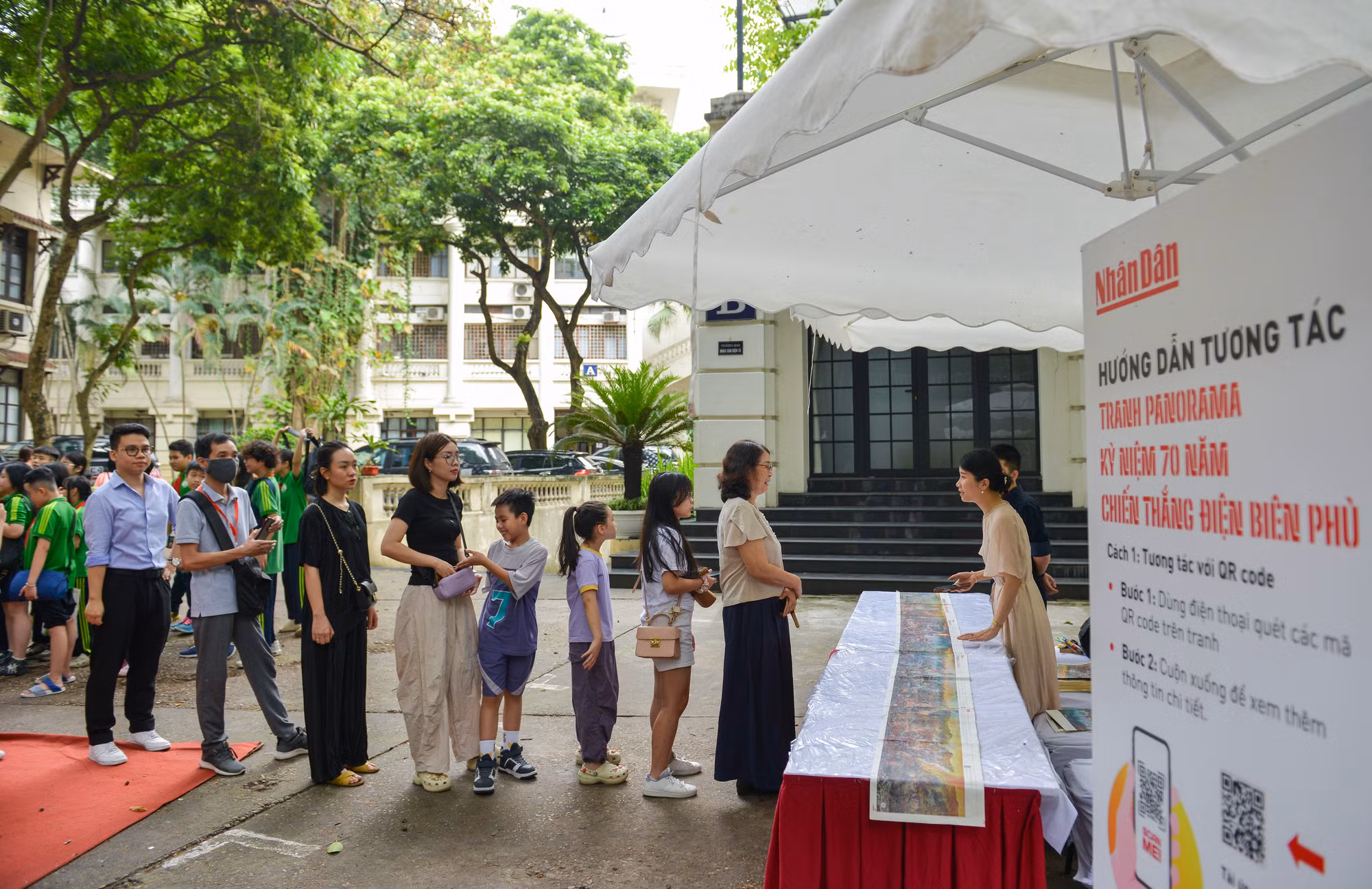 Bạn đọc xếp hàng để nhận ấn bản đặc biệt của Báo Nhân Dân in tranh panorama Chiến dịch Điện Biên Phủ.