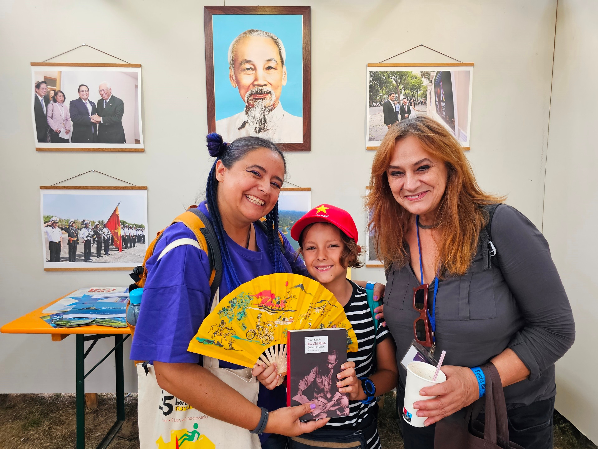 Chị Ana Mesquita (trái) cùng mẹ và con trai rất vui khi được chụp ảnh dưới chân dung Chủ tịch Hồ Chí Minh và được tặng sách về Người.