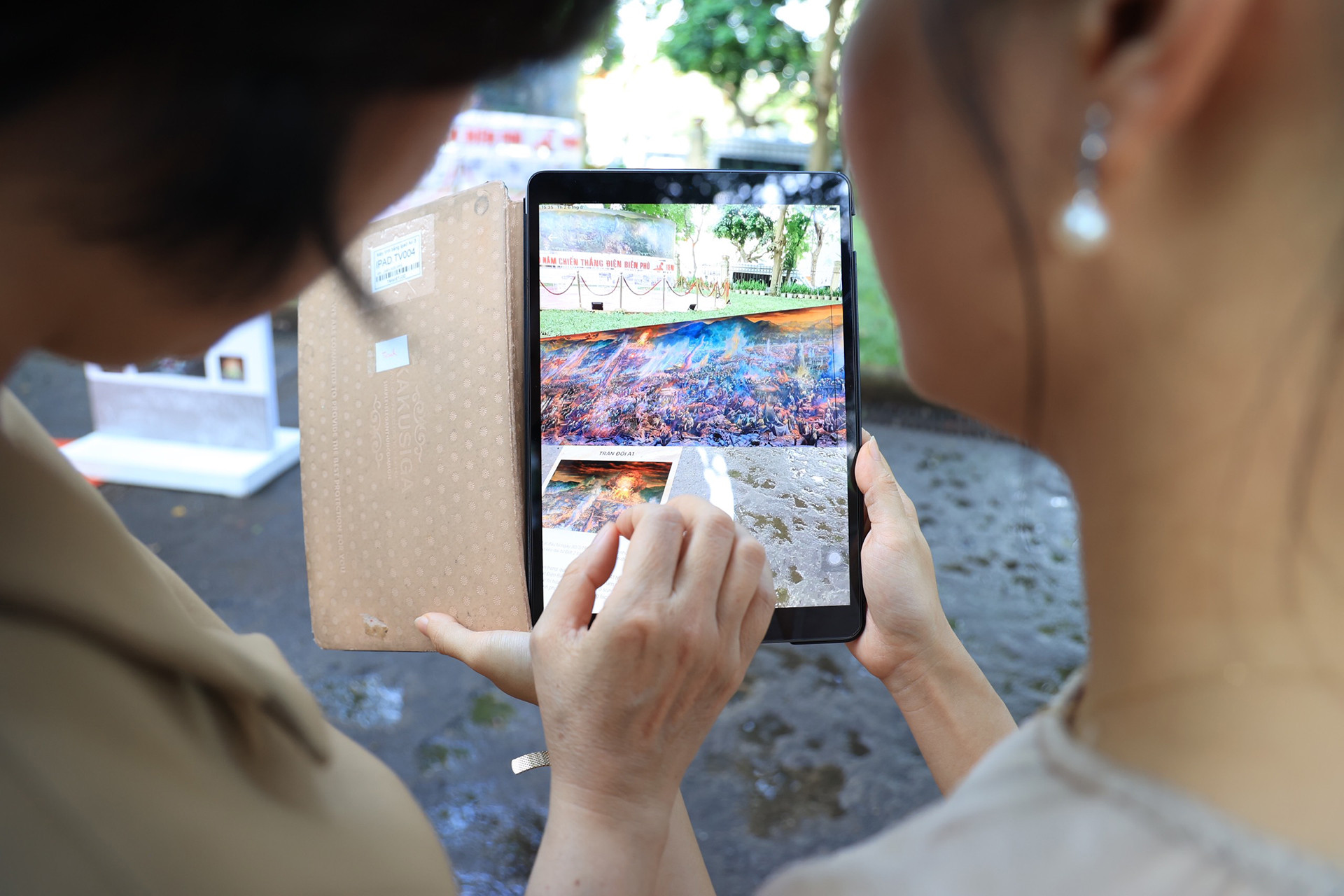 Đoàn viên thanh niên Báo Nhân Dân hướng dẫn công chúng trải nghiệm công nghệ thực tế tăng cường.