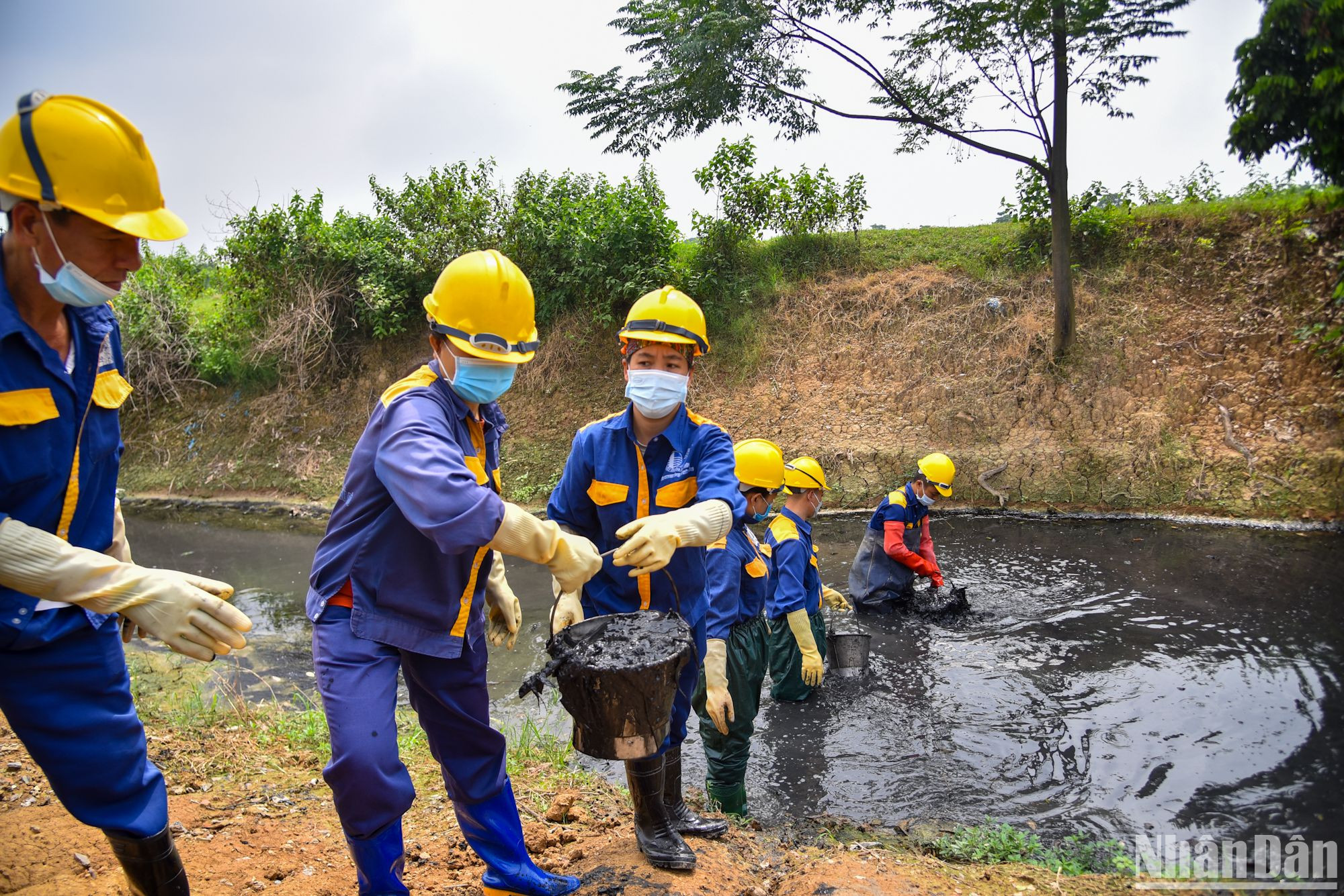 Những người công nhân chuyền tay nhau những xô chất thải để đem lên bờ xử lý. Những người công nhân chuyền tay nhau những xô chất thải để đem lên bờ xử lý.