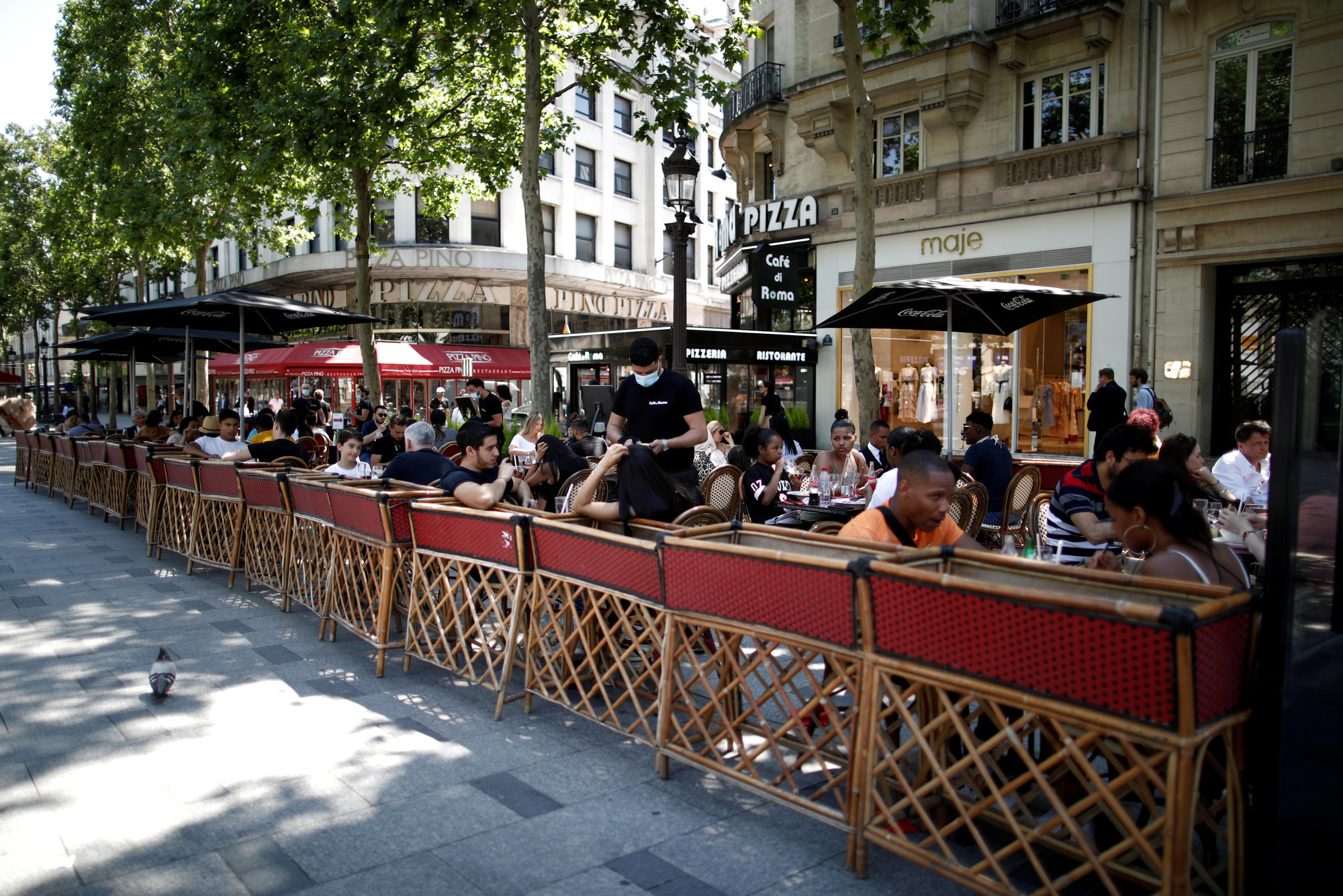Người dân ăn trưa tại một nhà hàng-cafe vỉa hè tại Paris. (Ảnh: Reuters)