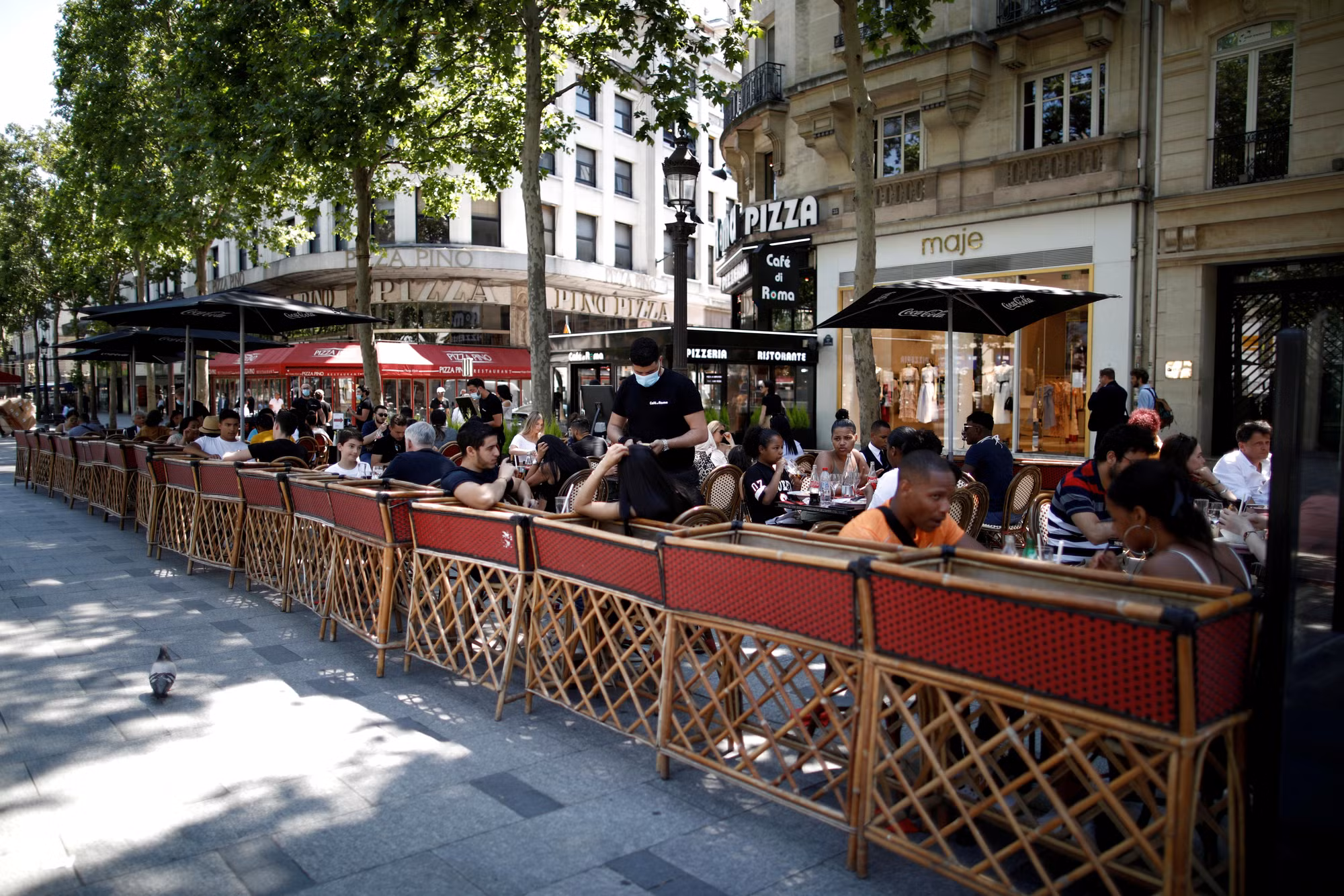 Người dân ăn trưa tại một nhà hàng-cafe vỉa hè tại Paris. (Ảnh: Reuters)