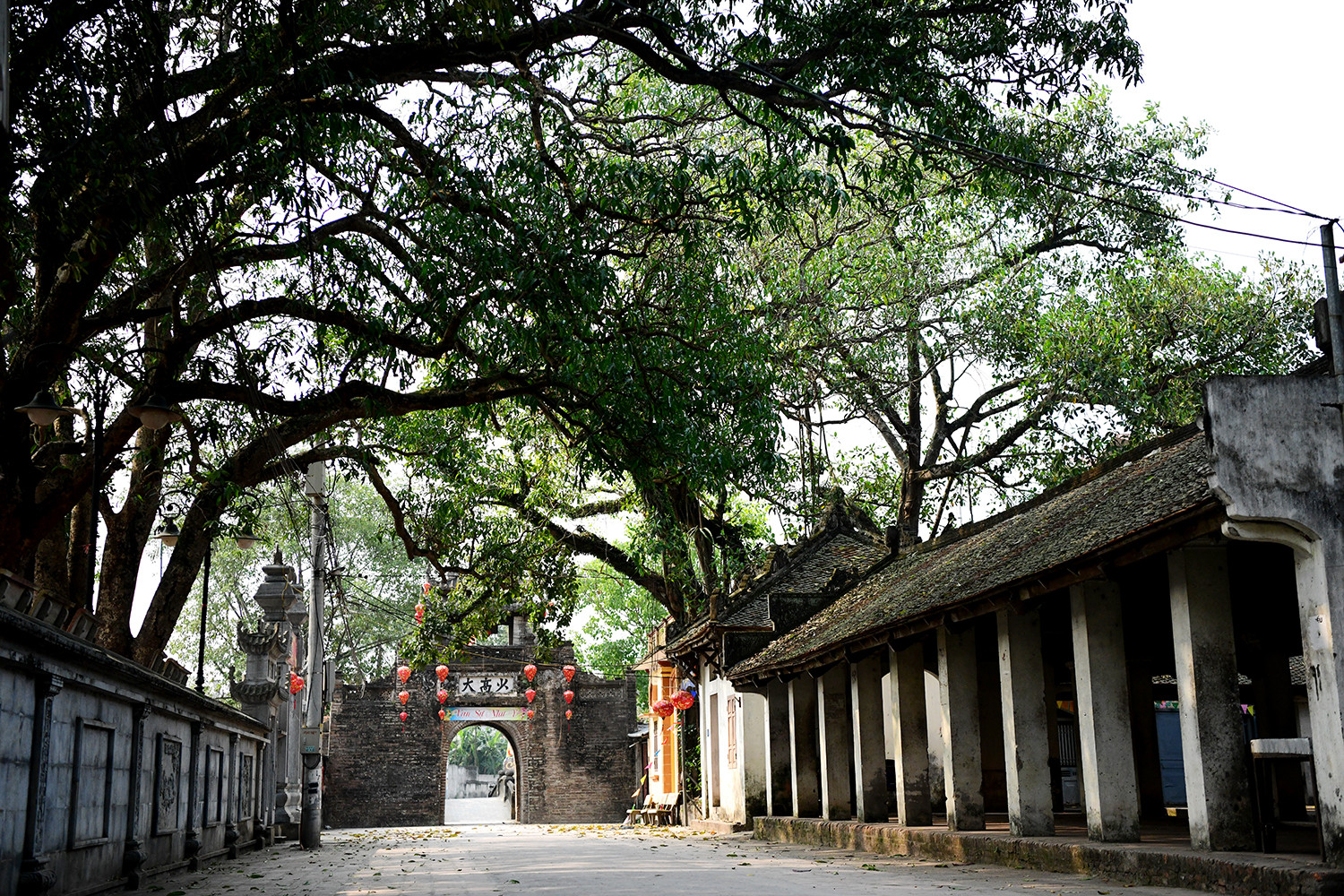 Bước qua cổng làng xưa cũ, những nếp nhà cổ kính hiện ra với cột kèo chạm khắc tinh xảo, vẫn giữ nguyên vẻ đẹp xưa. Những con ngõ nhỏ quanh co, tường gạch nhuốm màu thời gian..