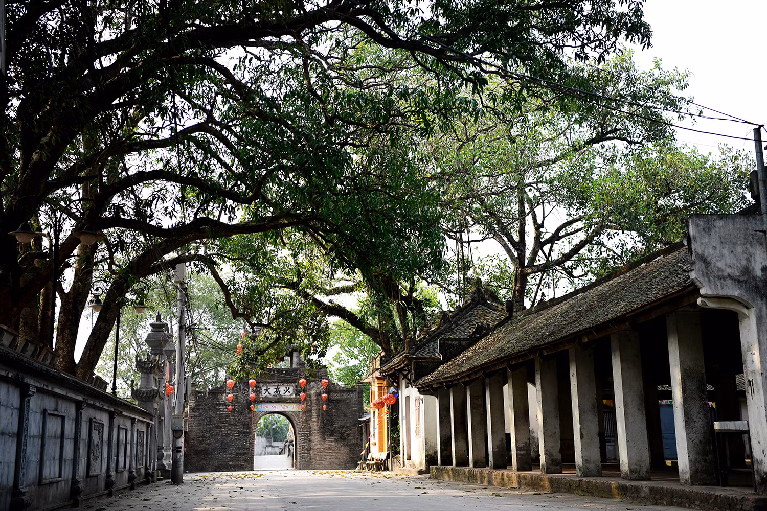 Bước qua cổng làng xưa cũ, những nếp nhà cổ kính hiện ra với cột kèo chạm khắc tinh xảo, vẫn giữ nguyên vẻ đẹp xưa. Những con ngõ nhỏ quanh co, tường gạch nhuốm màu thời gian..