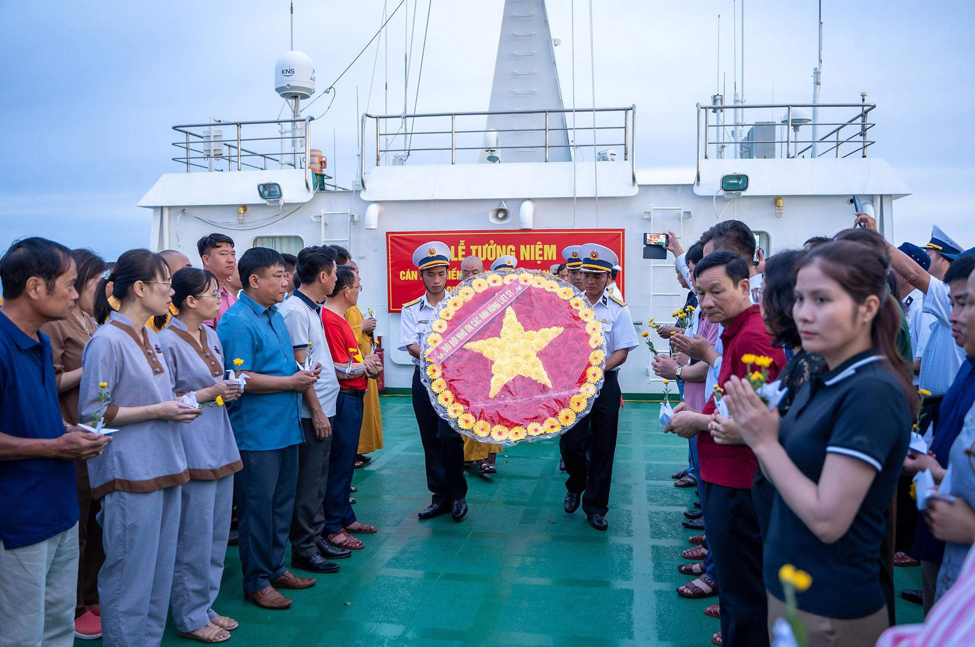 Sau lễ mặc niệm, vòng hoa “Đời đời nhớ ơn các anh hùng, liệt sĩ” được các chiến sĩ Hải quân làm lễ rước trang trọng giữa hai hàng đại biểu.