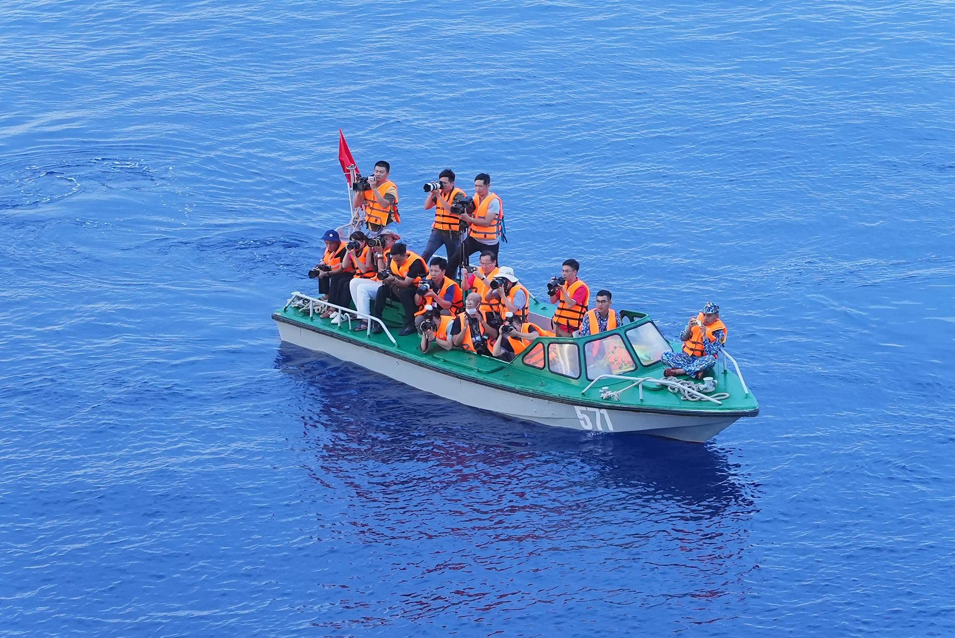 Các phóng viên, nhà báo cơ động rời tàu 571, bơi xuồng ra xa để ghi lại những hình ảnh Lễ tưởng niệm. (Ảnh: Quang Nam)
