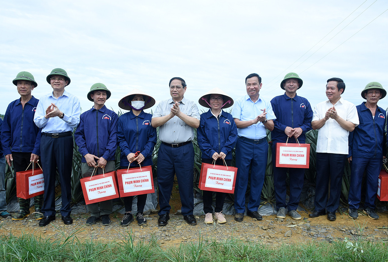 Thủ tướng Phạm Minh Chính tặng quà cho công nhân nông trường trồng dứa Đồng Giao.