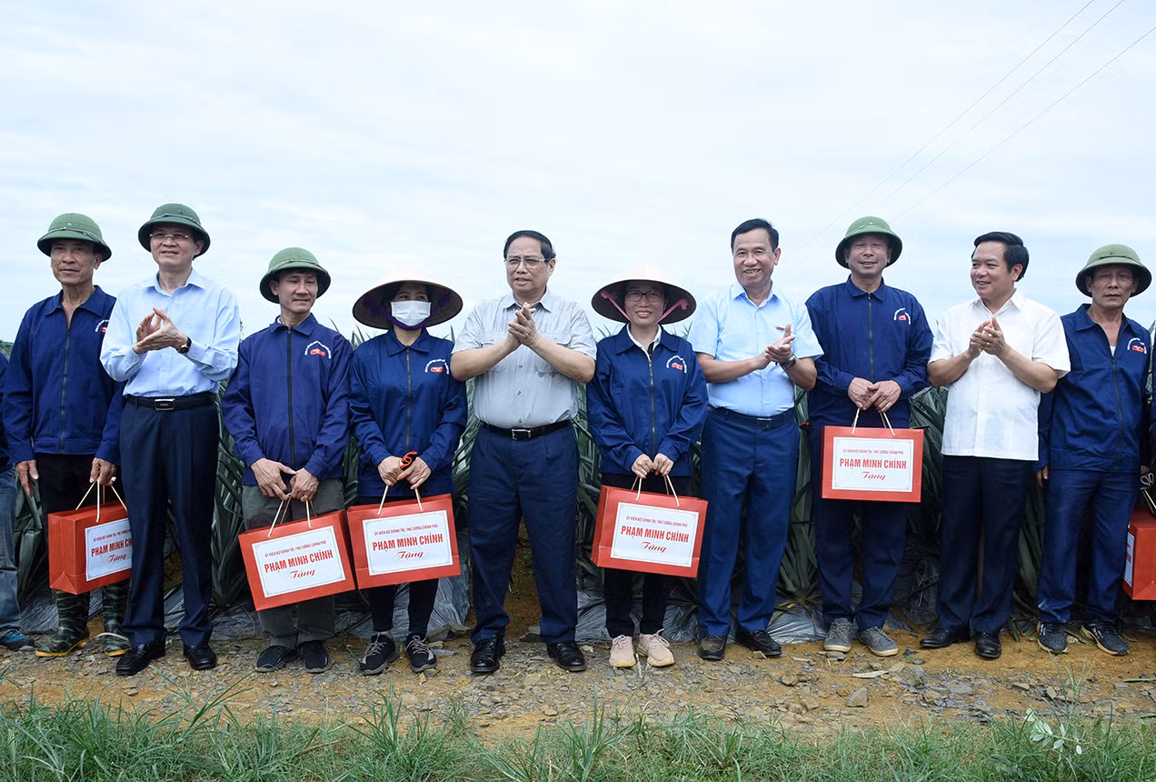 Thủ tướng Phạm Minh Chính tặng quà cho công nhân nông trường trồng dứa Đồng Giao.