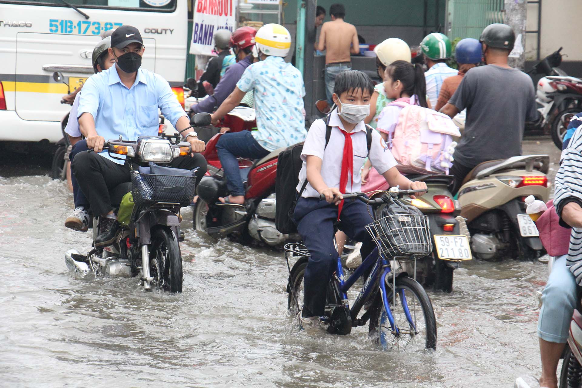 Khoảng 6 giờ, nước từ các con sông ồ ạt chảy vào đường Lê Văn Lương khiến việc đi lại của các em học sinh, người dân khá vất vả.