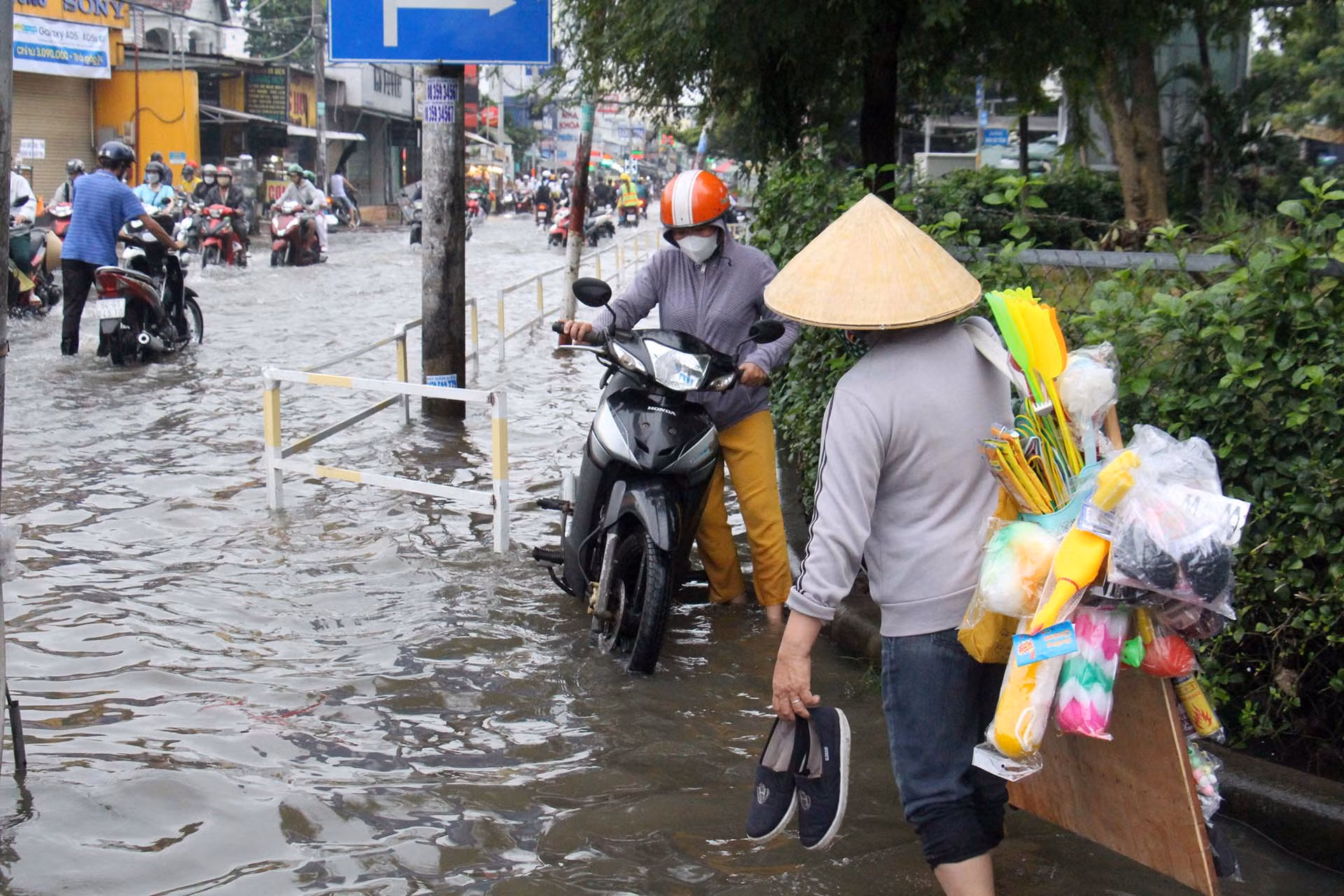 Để thuận lợi cho việc đi lại khi triều cường dâng cao, người bán hàng rong tranh thủ đi bán hàng rất sớm.