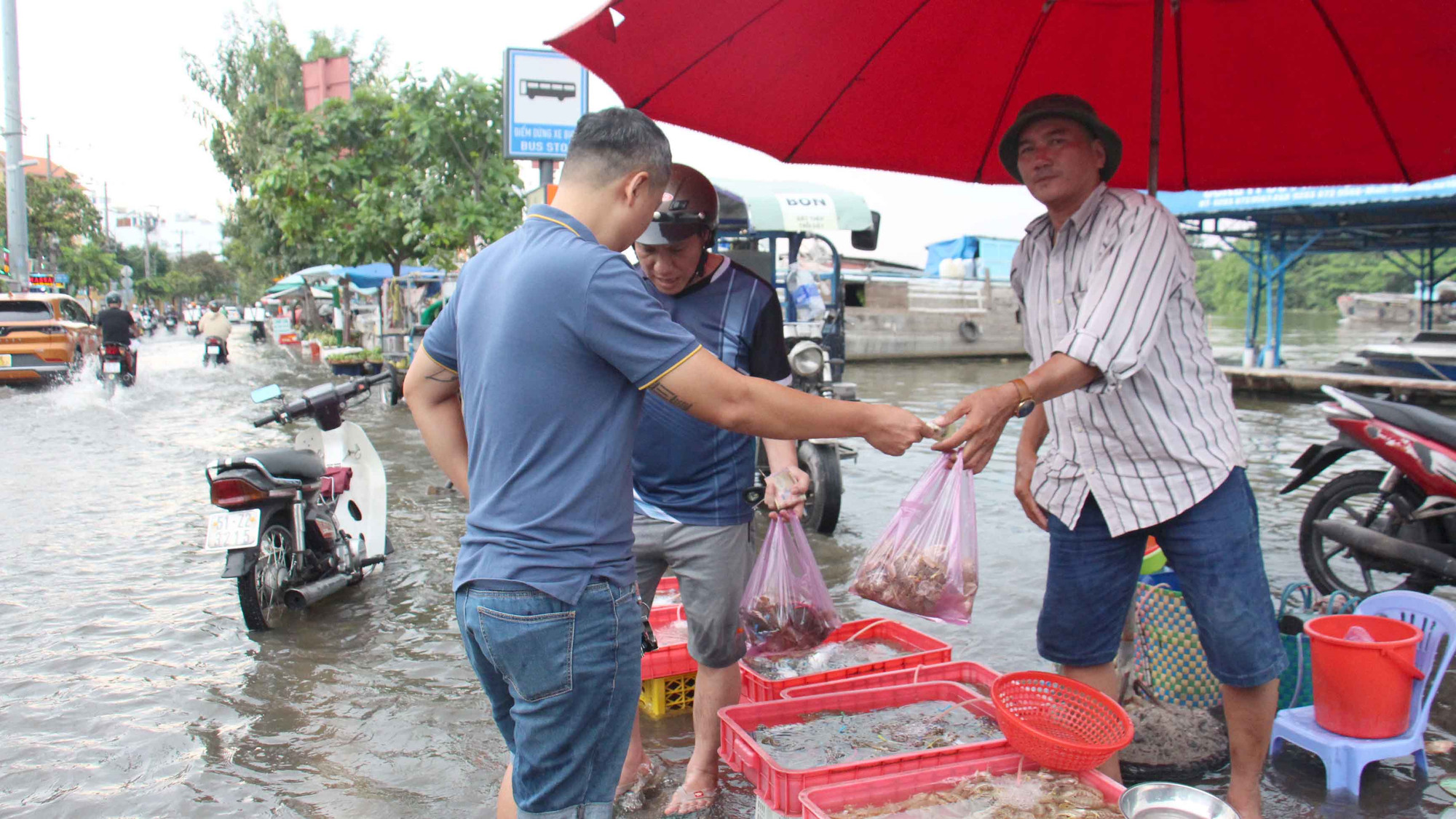 Người dân mua bán giữa dòng nước đen trên đường Trần Xuân Soạn.