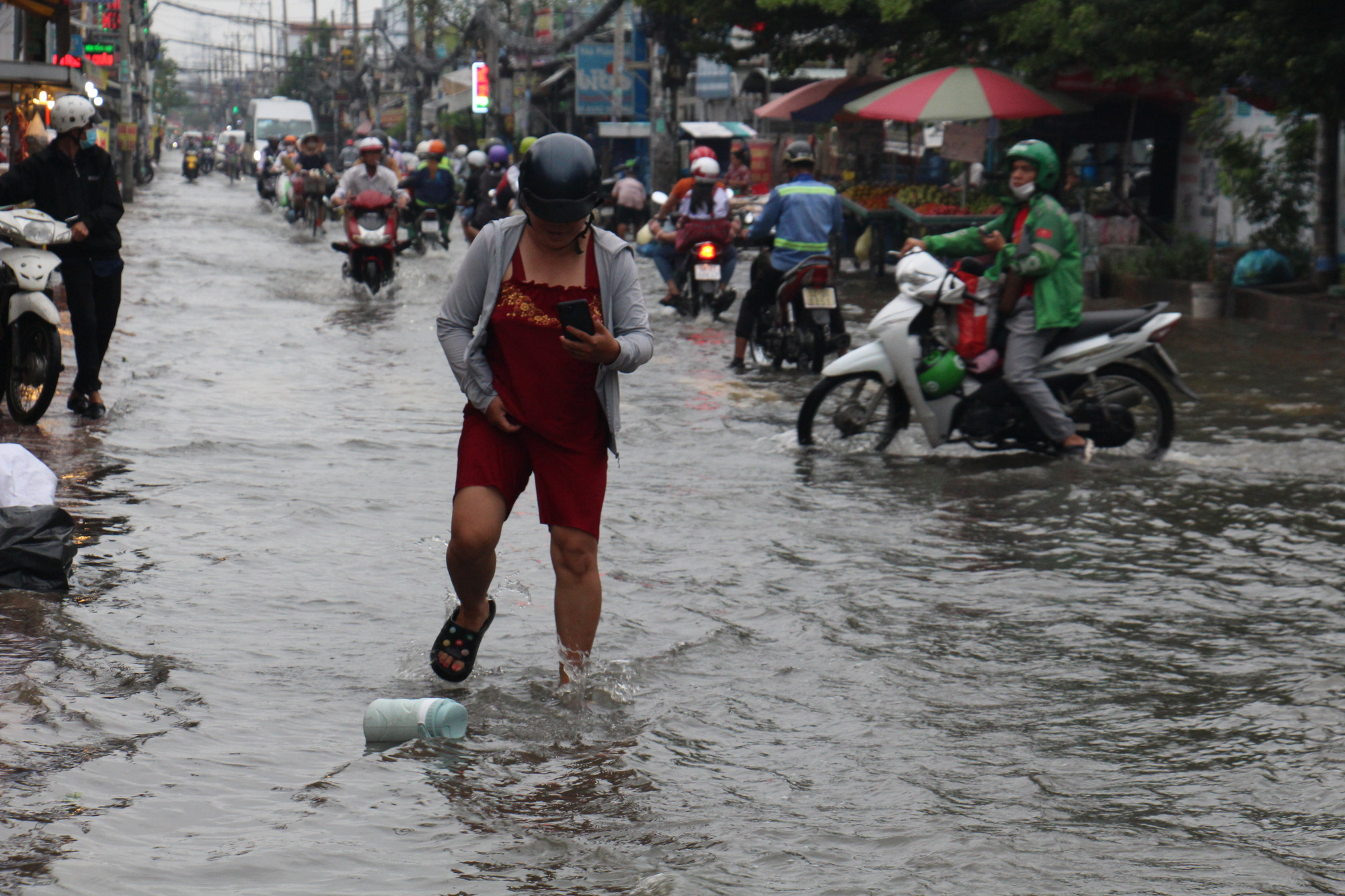 Đường Lê Văn Lương, nước ngập liên tục nhiều ngày khiến việc buôn bán ế ẩm, người dân đi lại khó khăn, học sinh té ngã khi qua đoạn ngập sâu.