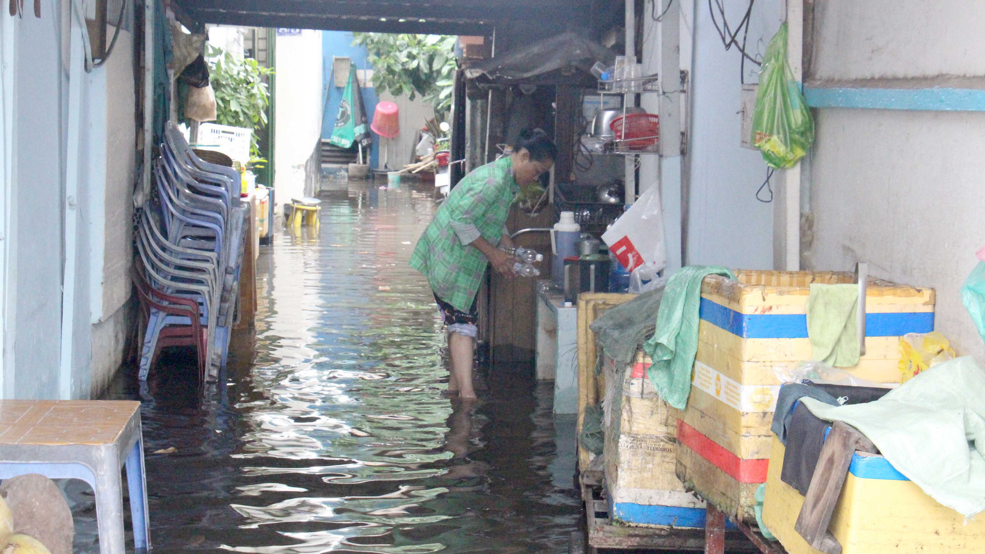Cô Lê Thị Thúy sống tại đường Trần Xuân Soạn, quận 7 phải lội dòng nước ngập để chuẩn bị buổi tối cho gia đình.