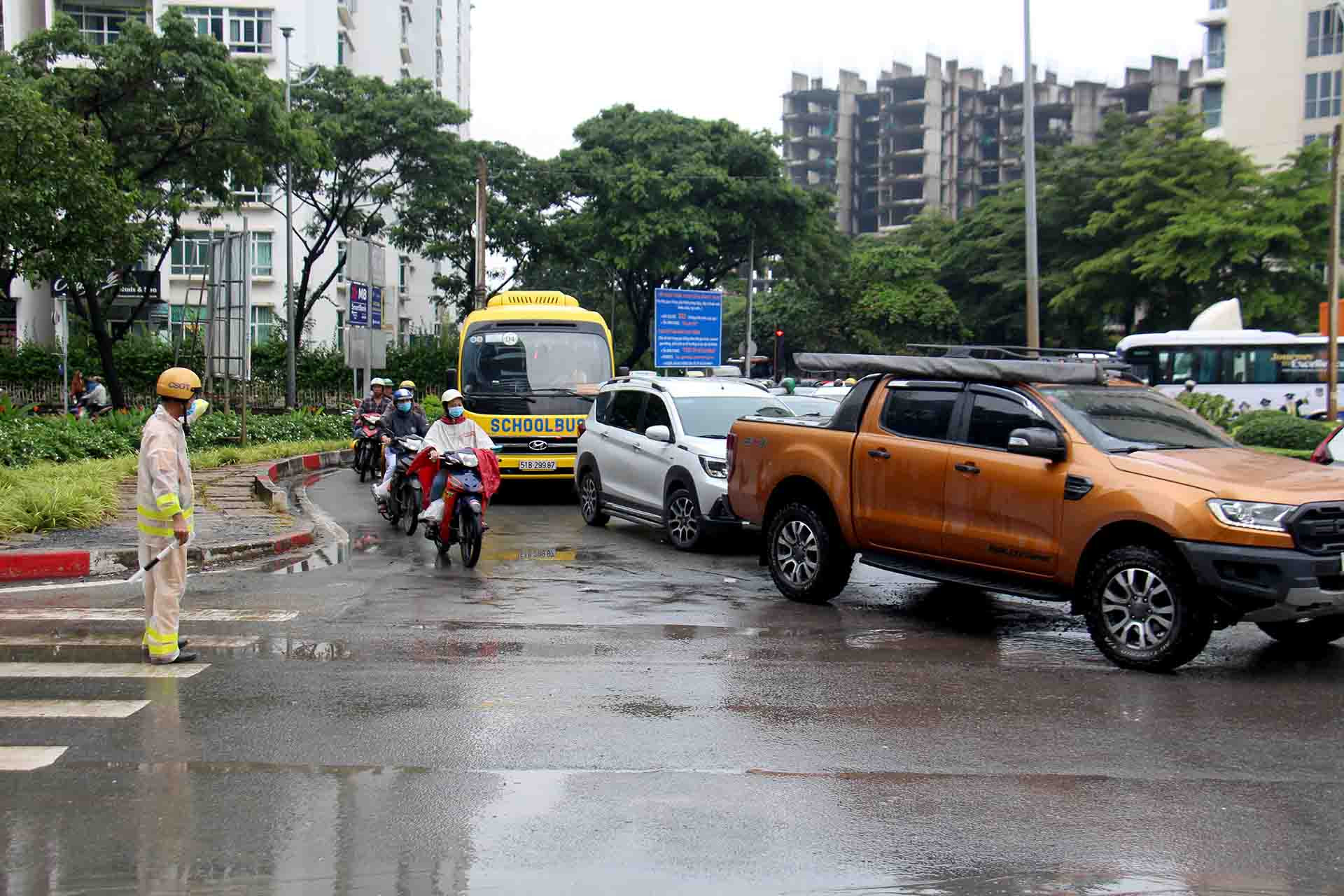 Từ sáng sớm, lực lượng cảnh sát giao thông phải đội nắng dầm mưa túc trực tại vòng xoay này để điều tiết giao thông.