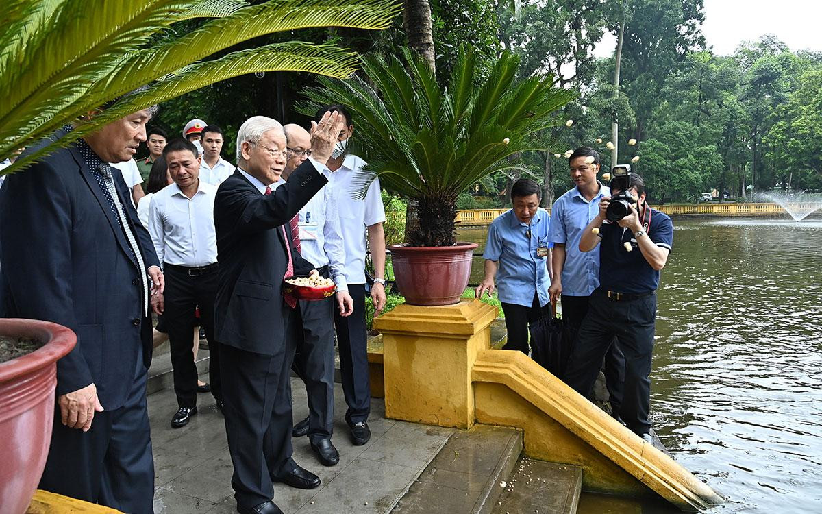 Tổng Bí thư Nguyễn Phú Trọng cho cá ăn tại ao cá Bác Hồ trong Khu Di tích Chủ tịch Hồ Chí Minh tại Phủ Chủ tịch.
