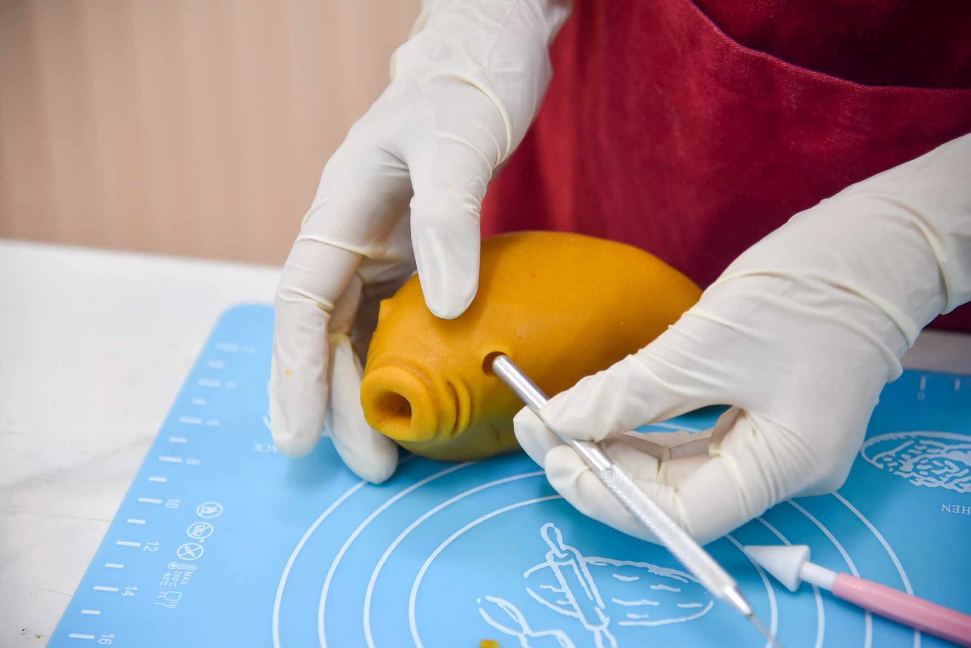 Thùy Dương dùng những dụng cụ hỗ trợ làm bánh để tạo mắt, miệng và vảy cho chú cá chép.