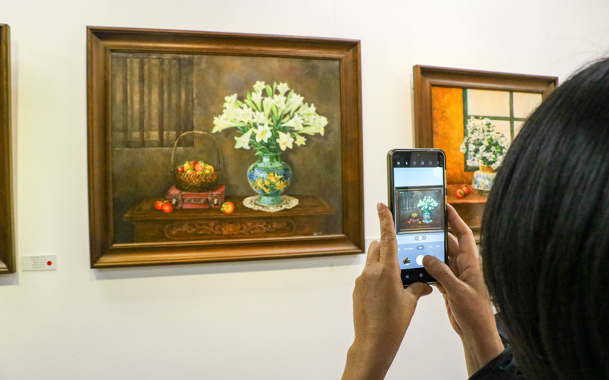 Người xem chụp lại những bức tranh đầy ấn tượng tại triển lãm.