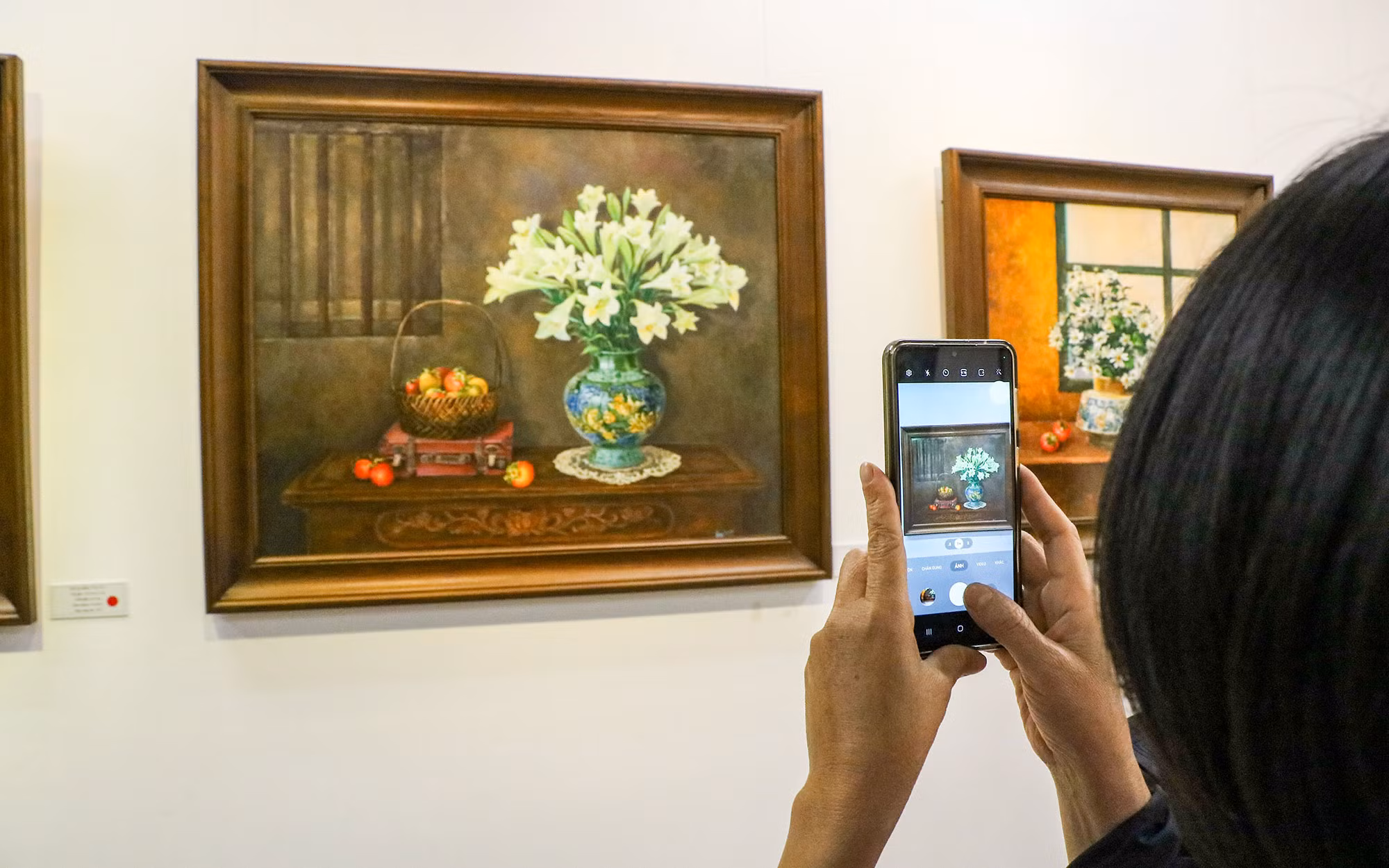 Người xem chụp lại những bức tranh đầy ấn tượng tại triển lãm.