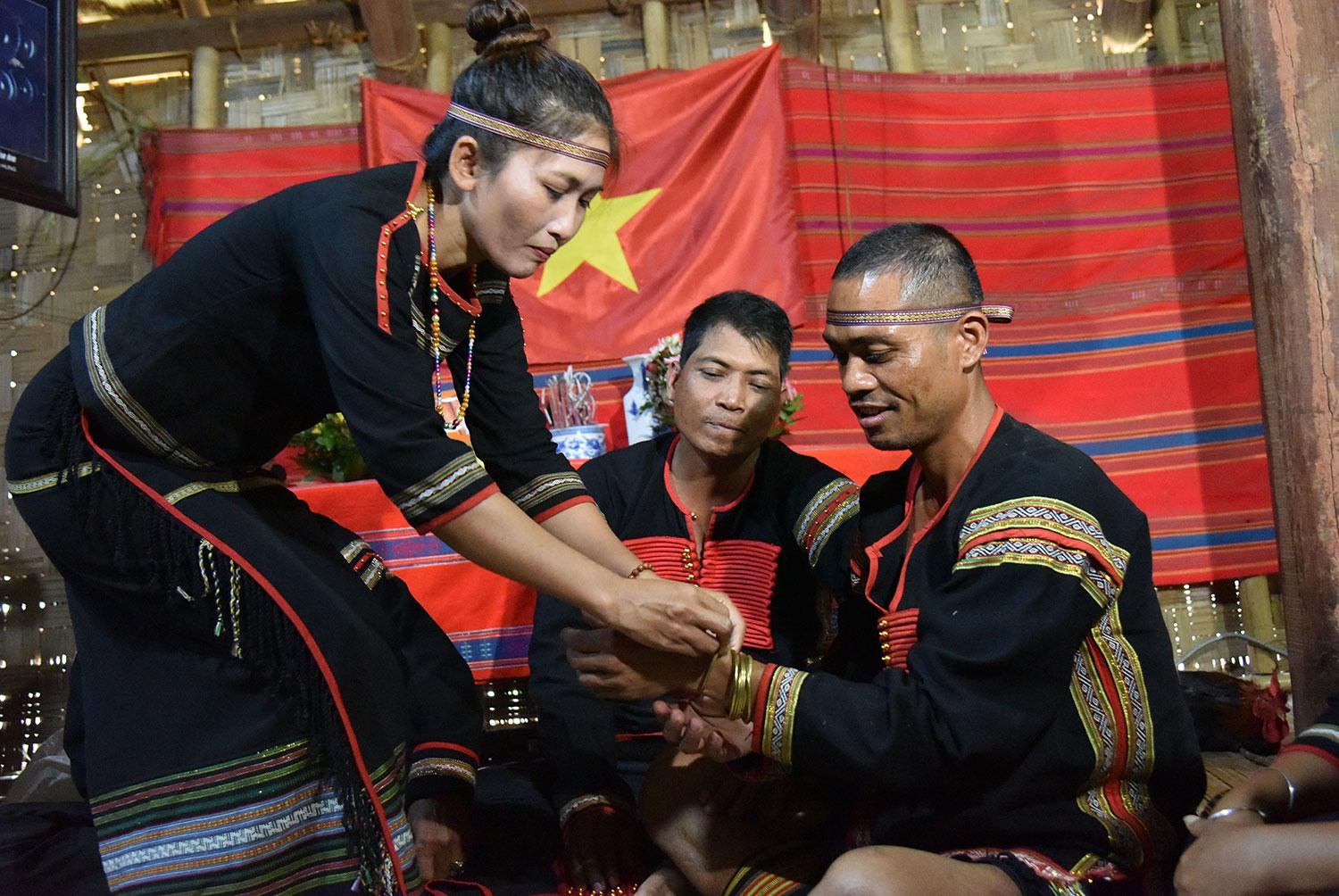 Nghi thức đeo vòng. (Ảnh: PHẠM TIỆP) Nghi thức đeo vòng. (Ảnh: PHẠM TIỆP)