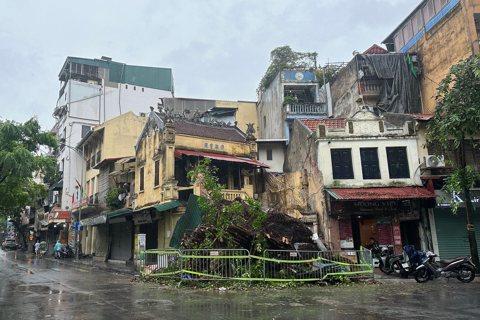 Khu vực cây to gãy đổ tại ngã tư phố Hàng Cá-Chả Cá được lực lượng chức năng phong tỏa để bảo đảm an toàn. (Ảnh: THỦY NGUYÊN)